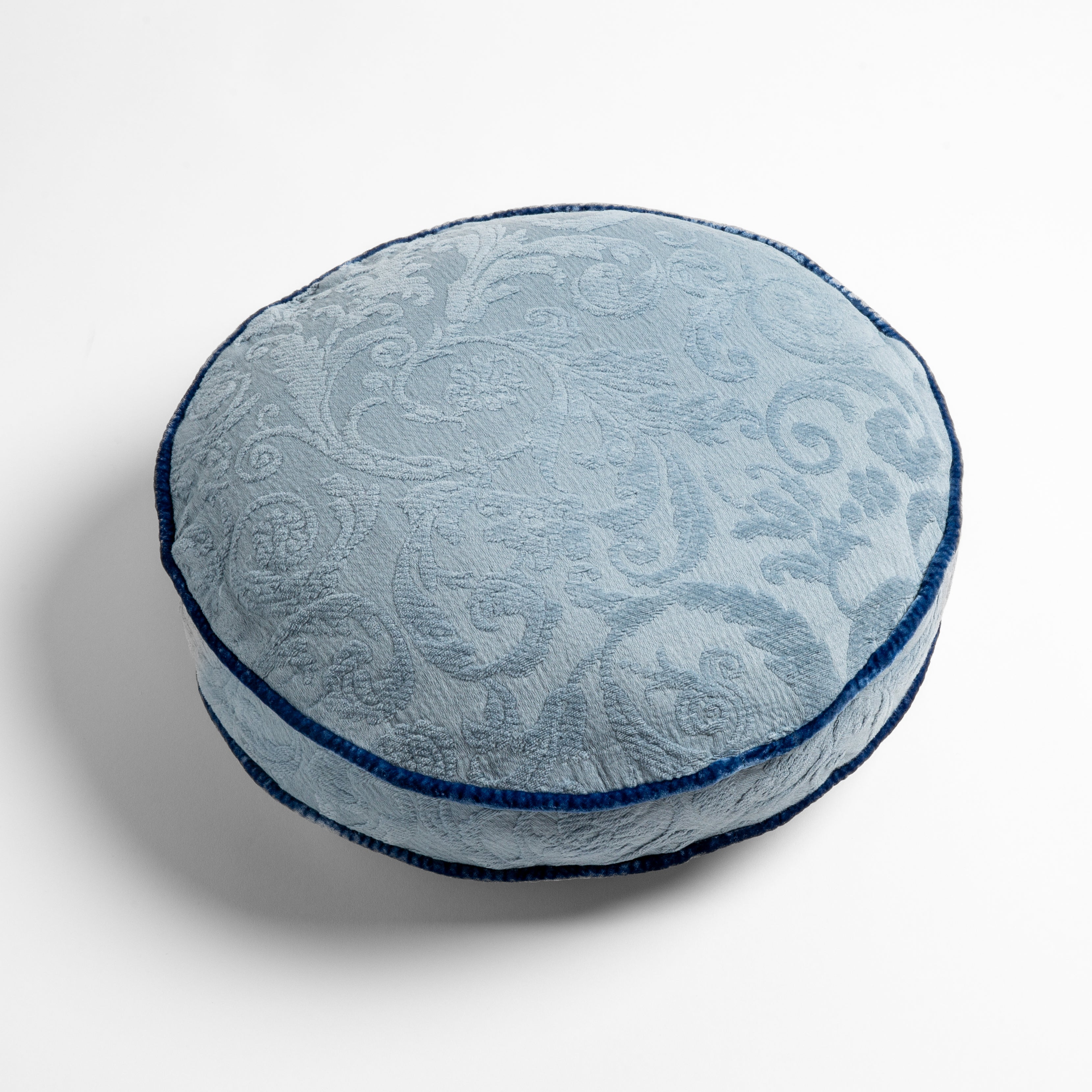 Tahoe Blue: Organic cotton damask round pillow with silk velvet trim on white background β overhead angle.
