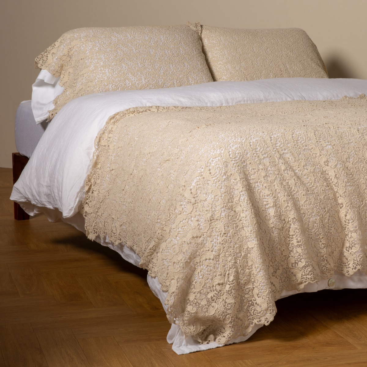 Parchment: cotton lace bed scarf draped across the foot of a bed dressed in linen sheets and duvet cover in winter white - shown with matching lace pillowcase covers over a linen liner in winter white.