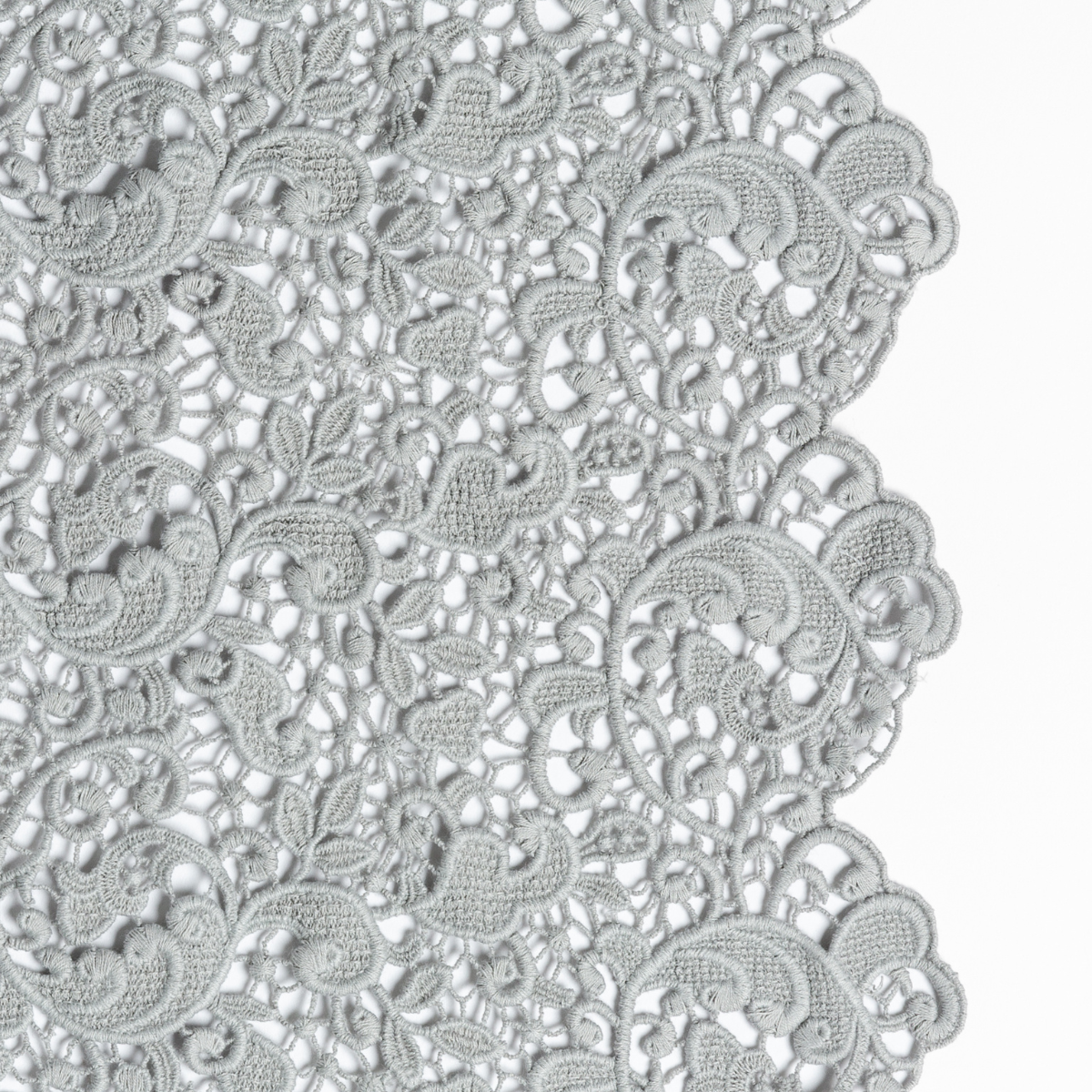 Mineral: a close up of cotton all-over lace with a scalloped edge.