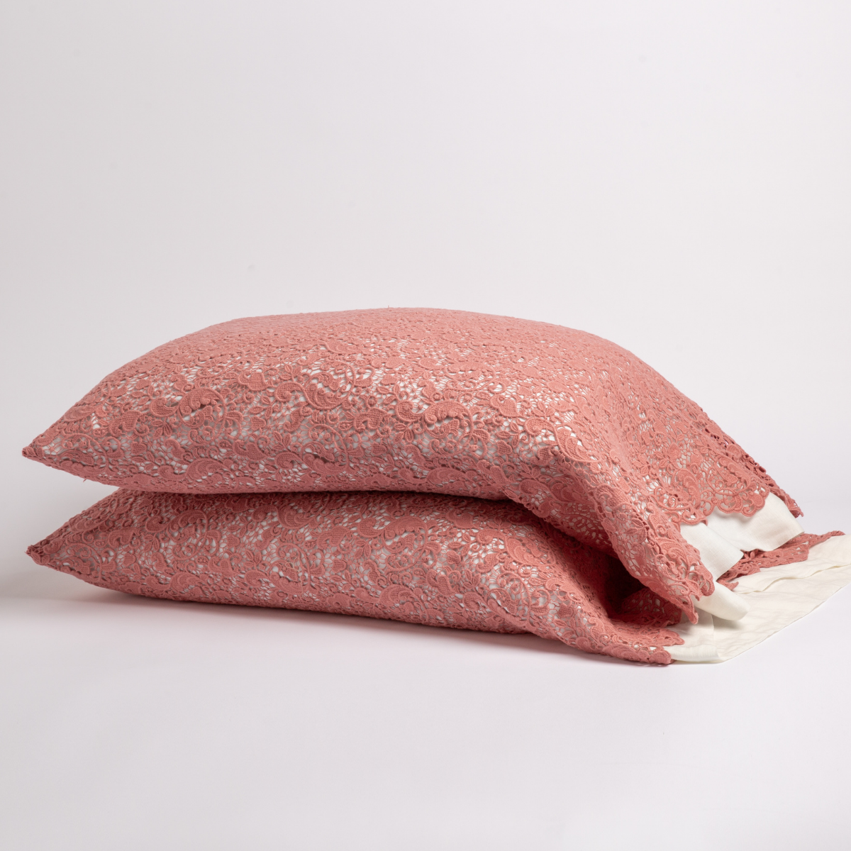 Poppy: a pair of stacked cotton lace pillowcase covers on winter white liners against a white background.
