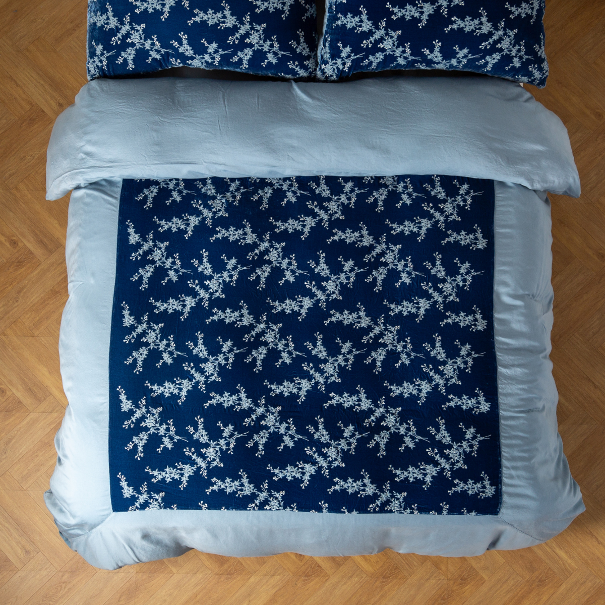 Tahoe Blue: An overhead shot of an embroidered silk velvet and tencel duvet cover and matching shams.