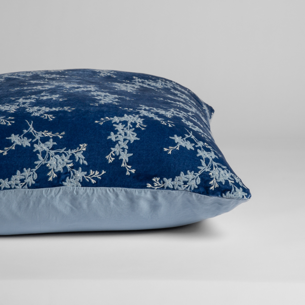 Tahoe Blue: A close-up of the sham shown on its side to display the embroidered silk velvet face and tencel back — shown against a white background.