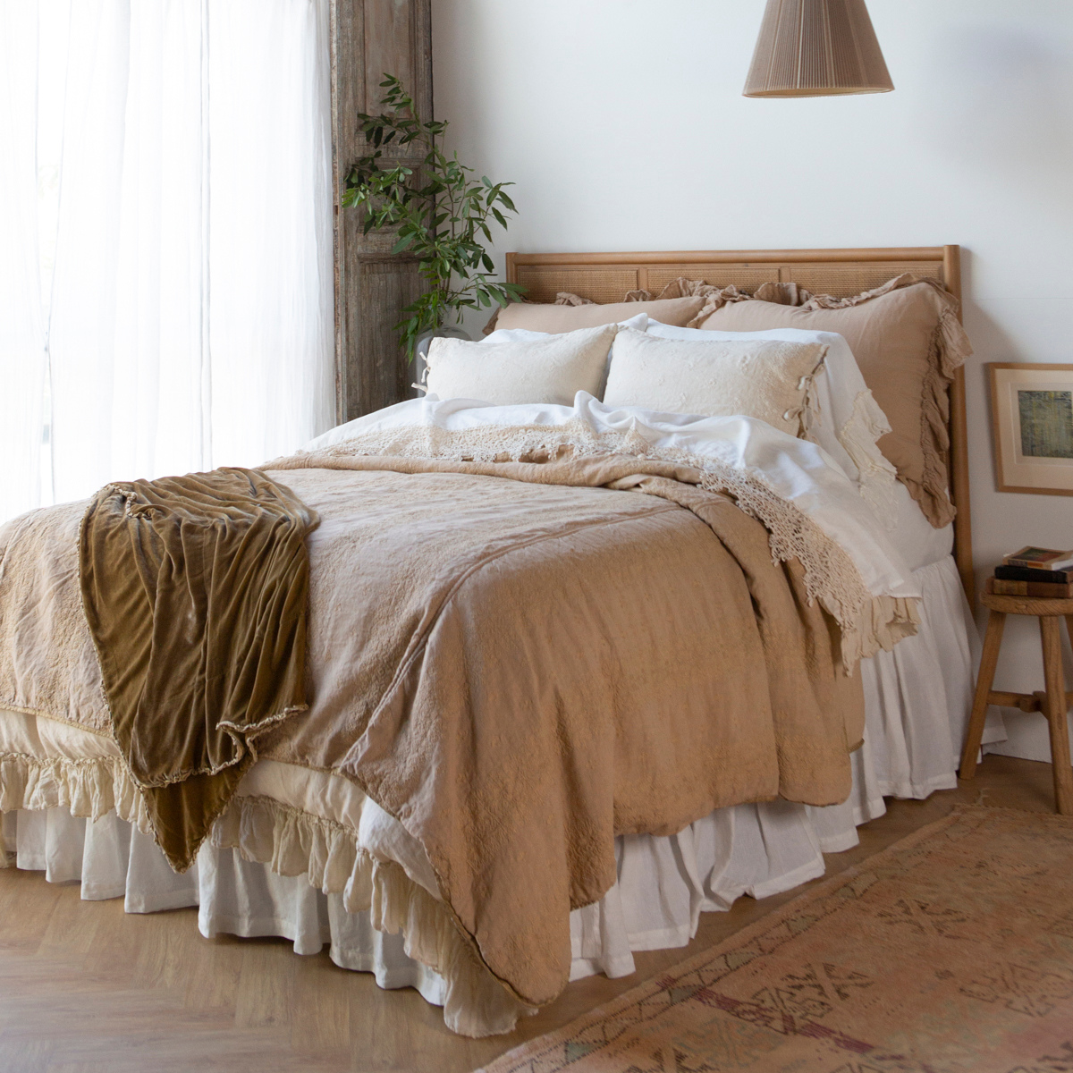: Bedspread in honeycomb layered under a creamy ruffled duvet - close up angled view.