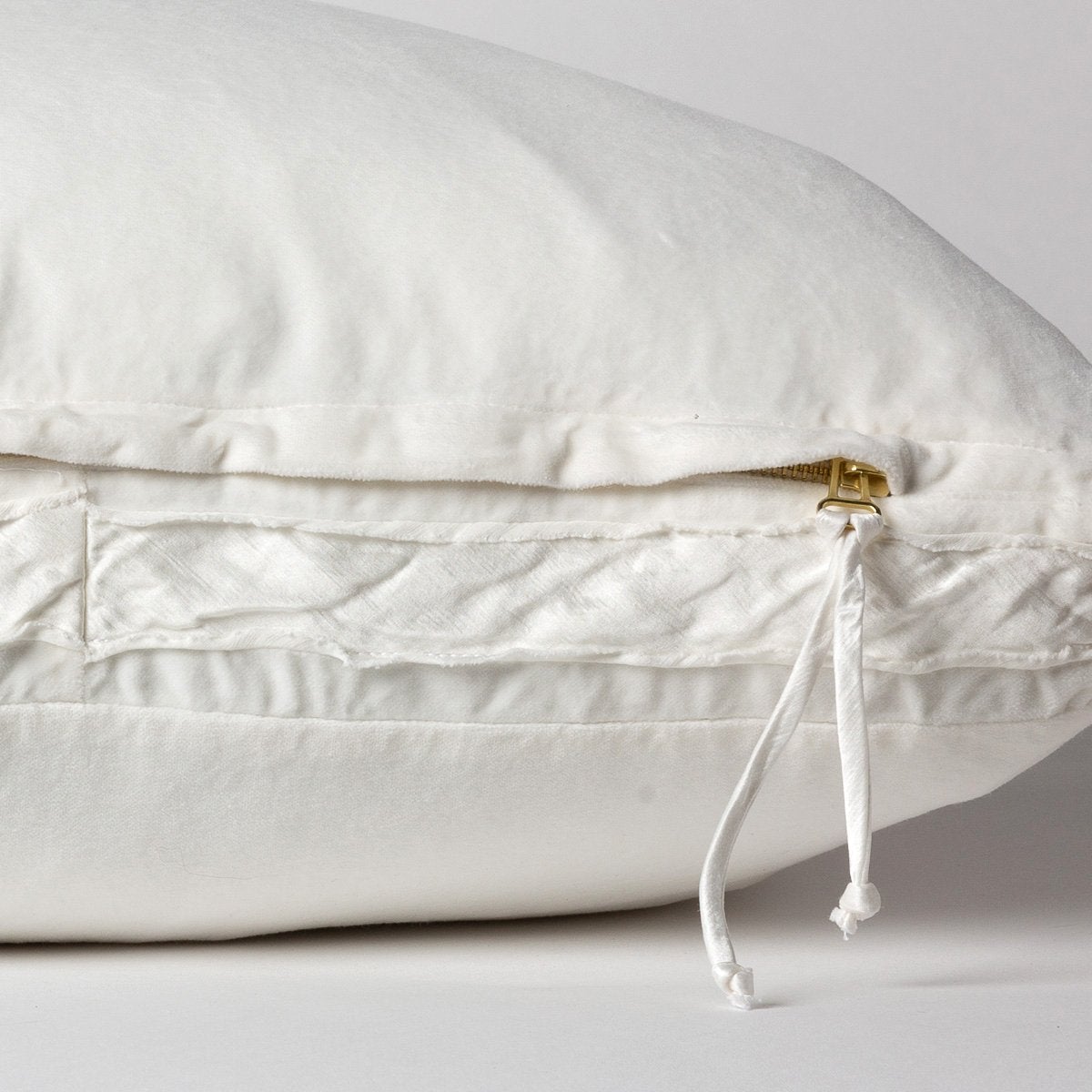 Winter White: Close-up of charmeuse gusset, raw-edge trim, and brass zipper detail on cotton velvet sham - side view.