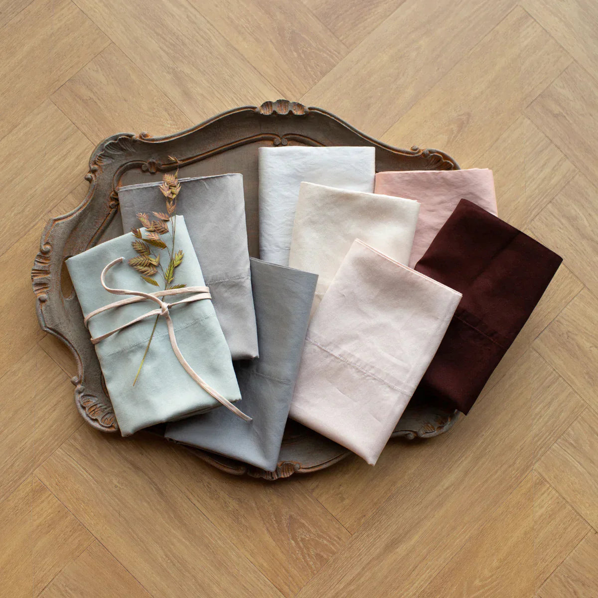 : Bria pillowcases in a variety of colors neatly folded and fanned on a tray - overhead view.
