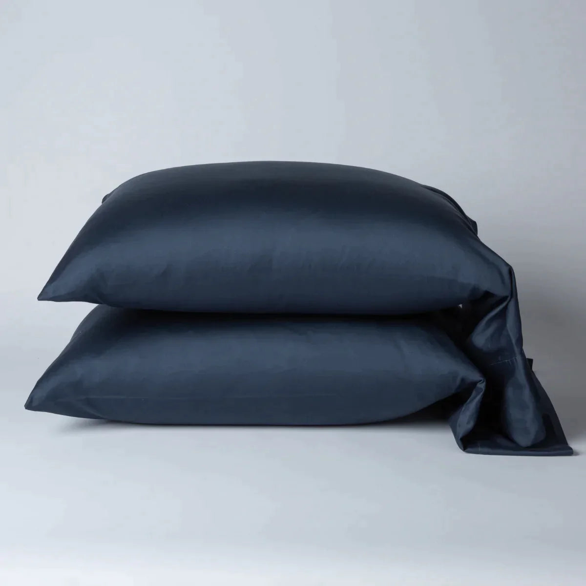 Midnight: Two cotton sateen sleeping pillows, stacked neatly against a white backdrop - side view.