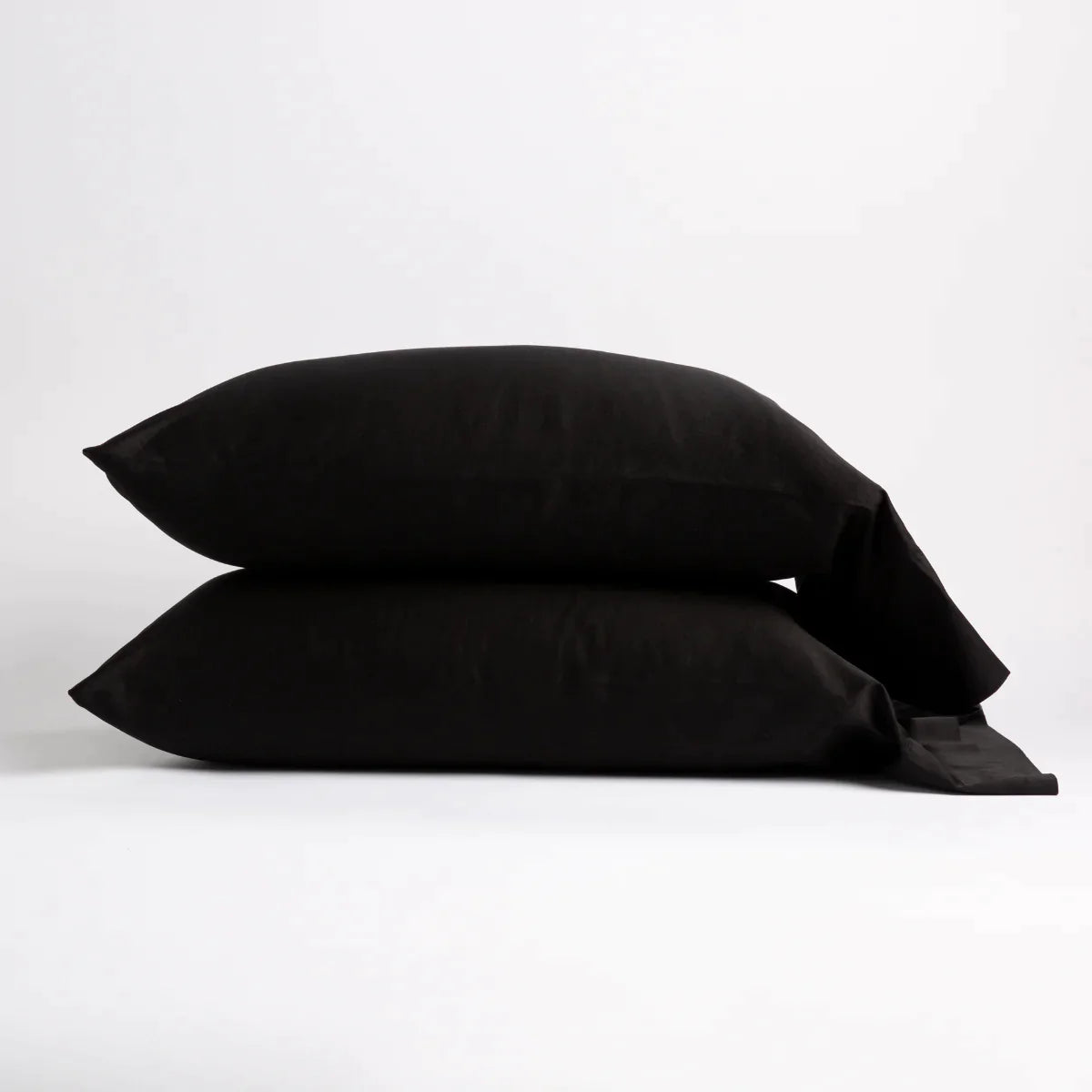 Corvino: Two cotton sateen sleeping pillows, stacked neatly against a white backdrop - side view.