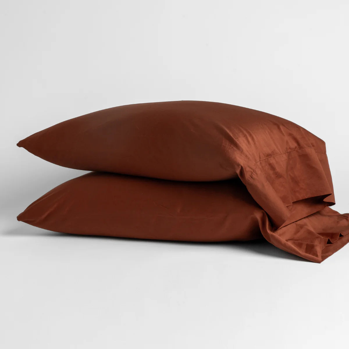 Autumn: Two cotton sateen sleeping pillows, stacked neatly against a white backdrop - side view.