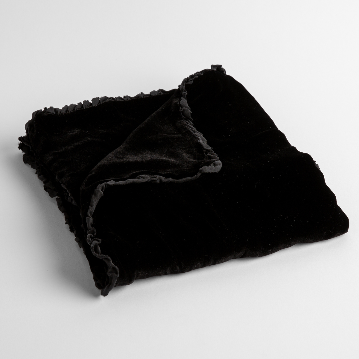 Corvino: silk velvet baby blanket with charmeuse trim shown slightly overhead with a corner folded back to show trim detail against a white background.