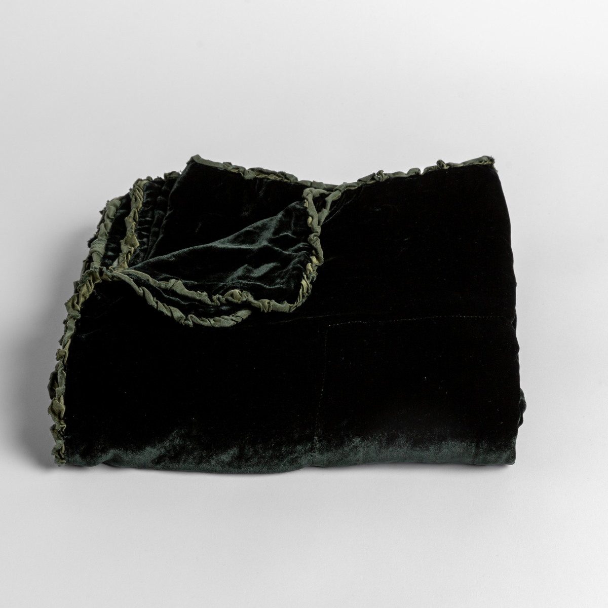 Juniper: silk velvet baby blanket with charmeuse trim shown slightly overhead with a corner folded back to show trim detail against a white background.