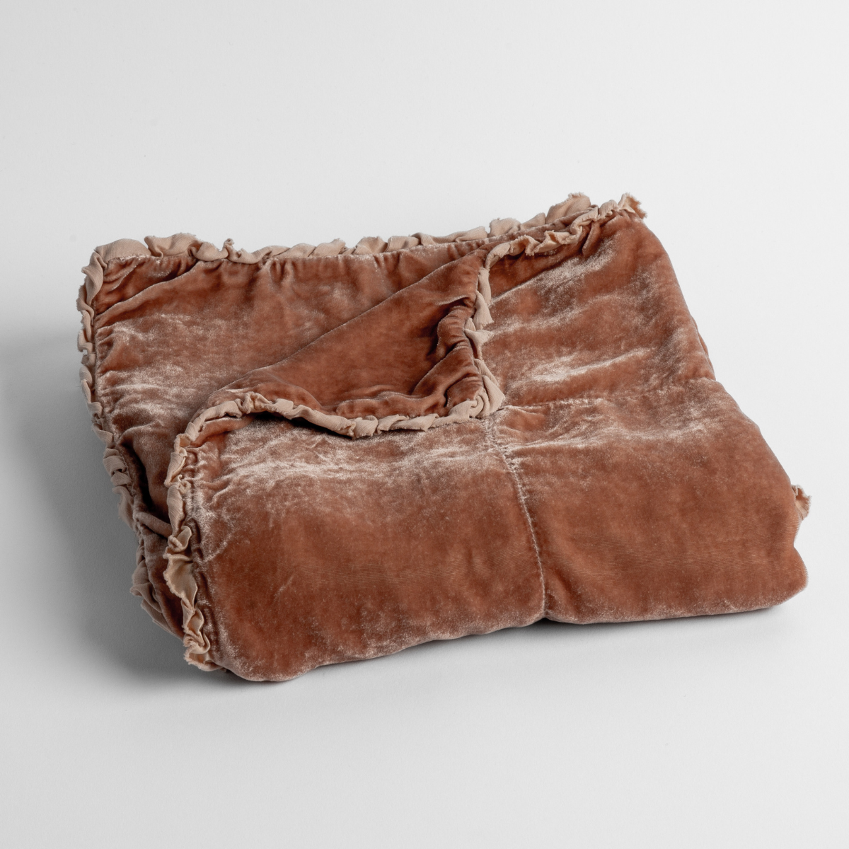 Rouge: silk velvet baby blanket with charmeuse trim shown slightly overhead with a corner folded back to show trim detail against a white background.