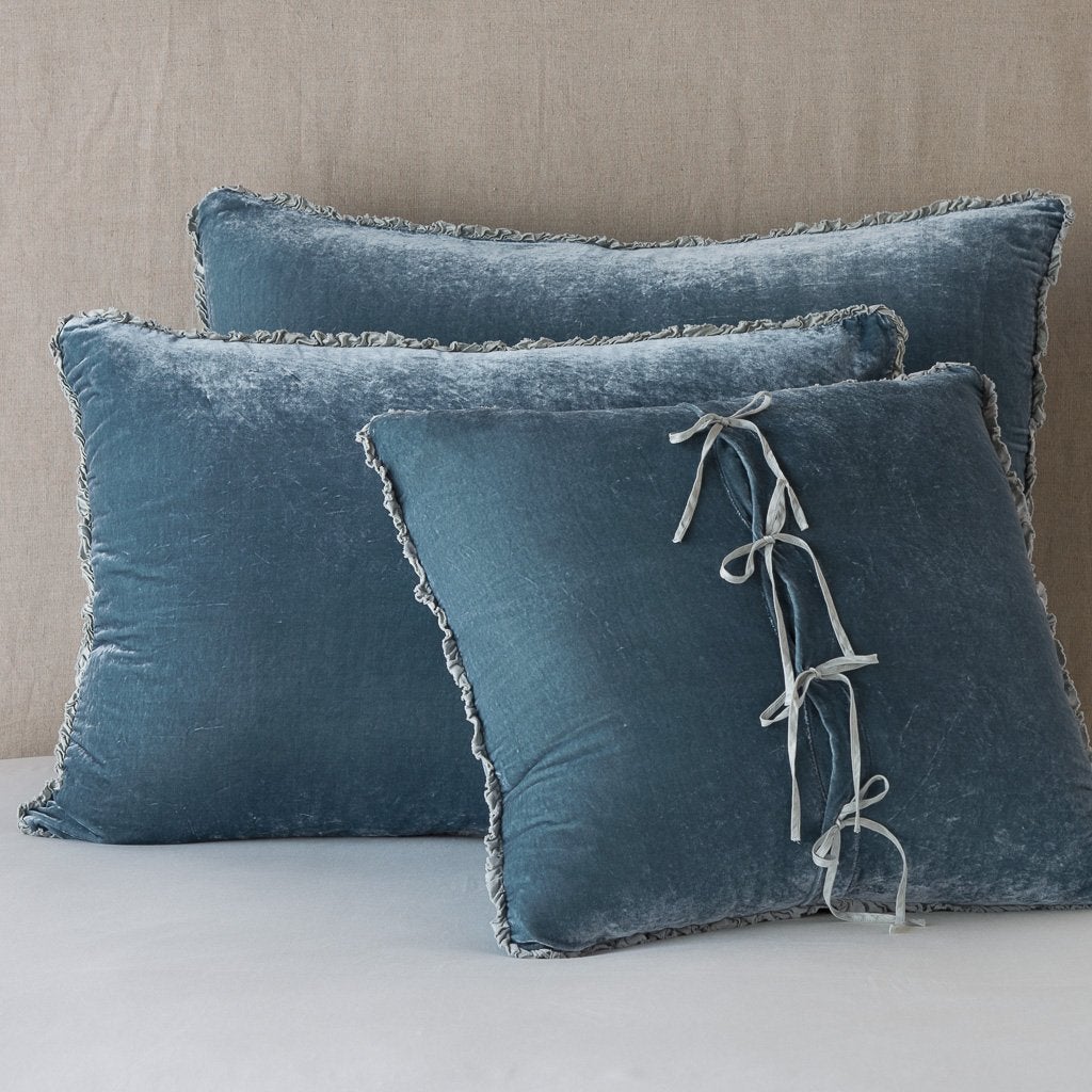 Mineral: Silk velvet shams with a petite ruffle leaning upright against a neutral headboard. The front sham is backwards, showcasing the charmeuse tie closures.