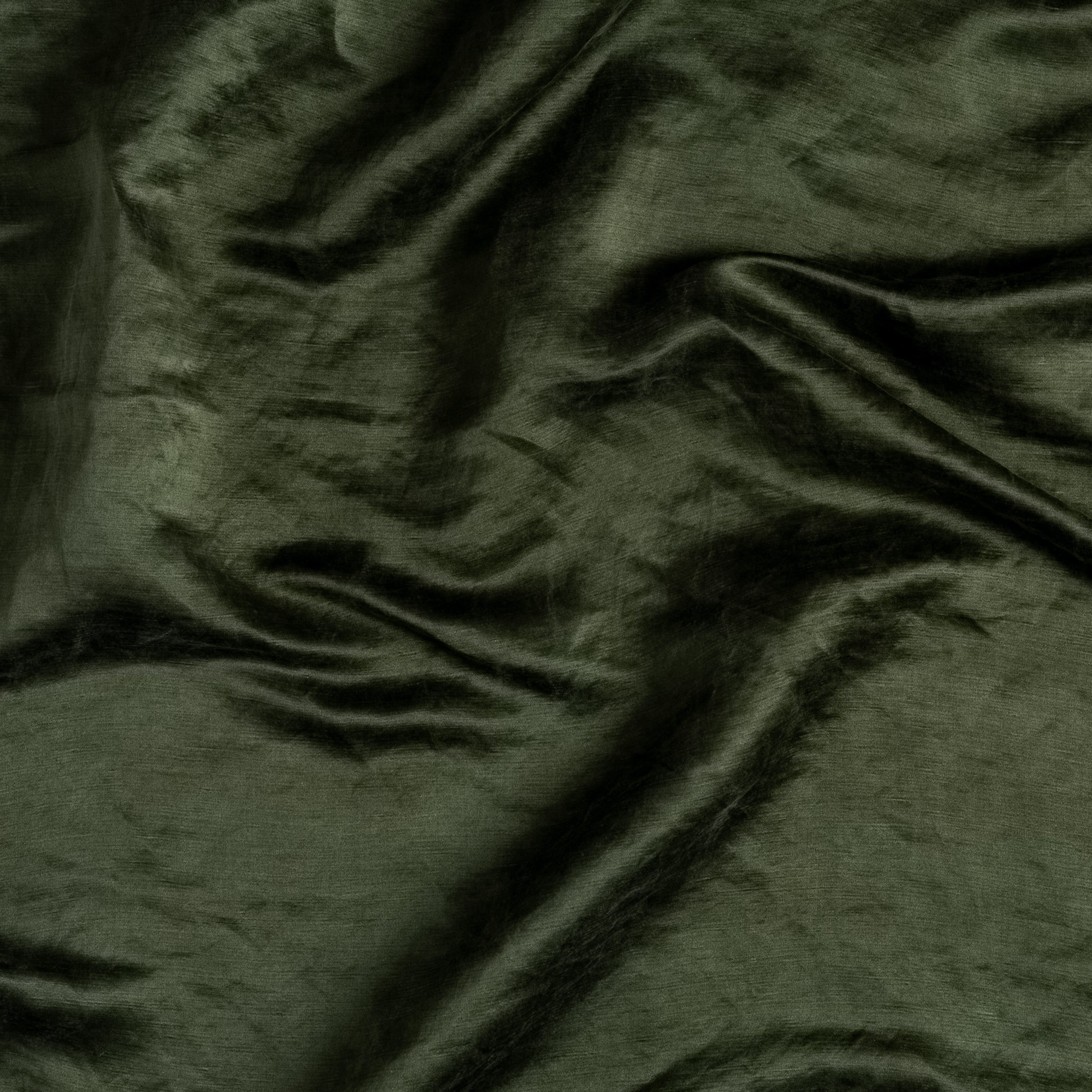 A close up of charmeuse fabric in juniper, a deep green tone, gently rumpled.
