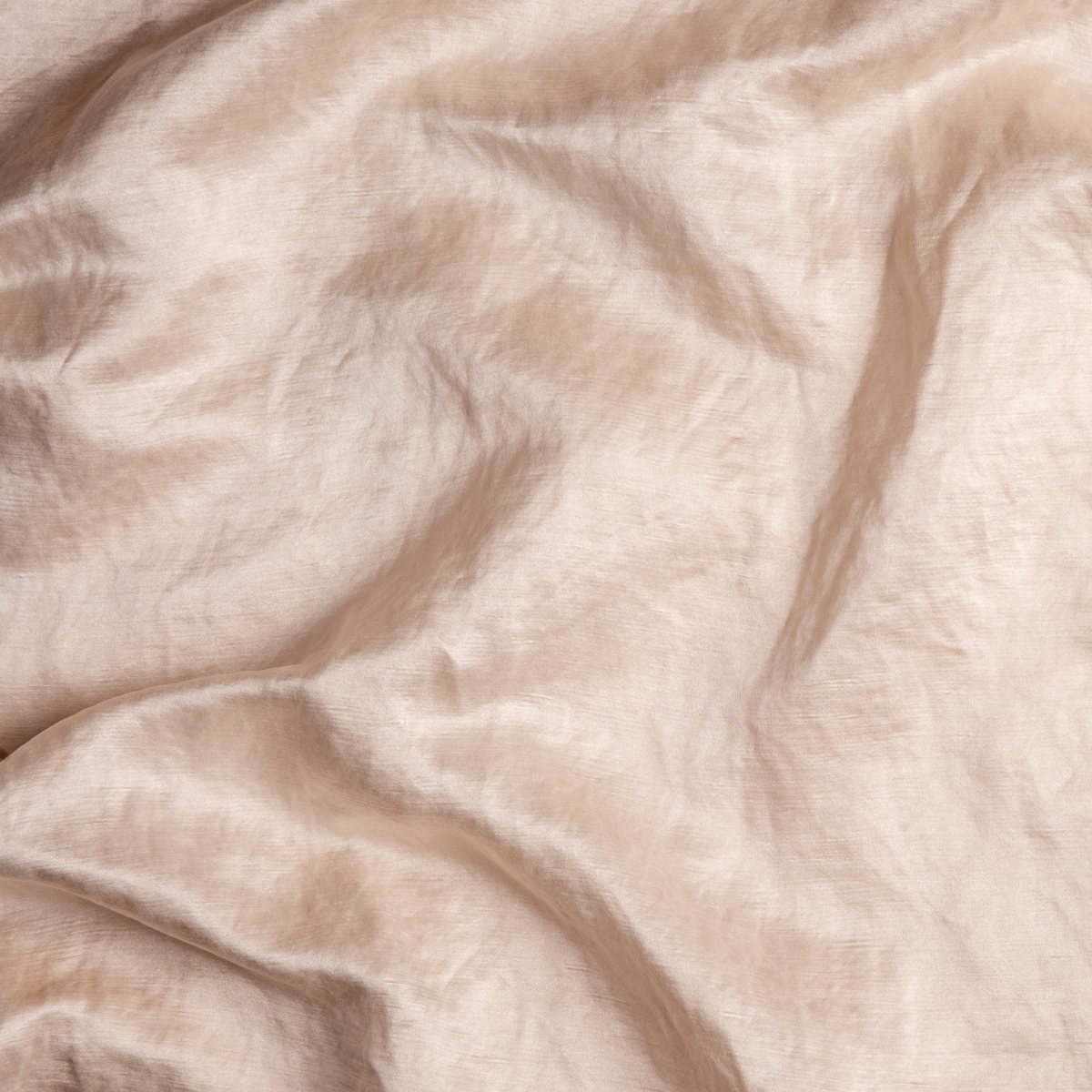 Pearl: A close up of charmeuse fabric in pearl, a nude-like, soft rose pink tone.