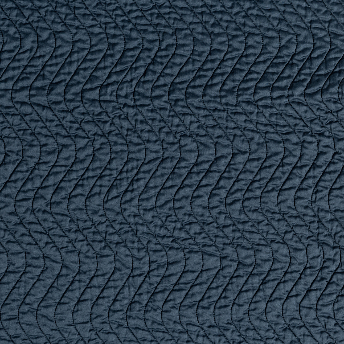 Midnight: A close up of quilted cotton sateen fabric in midnight, a rich indigo tone.