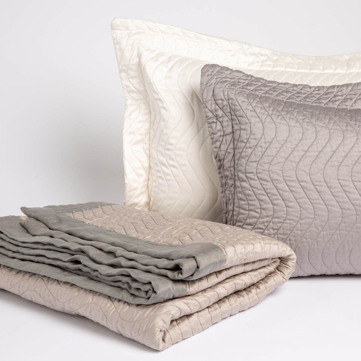 : two qulted cotton sateen throw pillows with a throw blanket trimmed in unquilted cotton sateen.