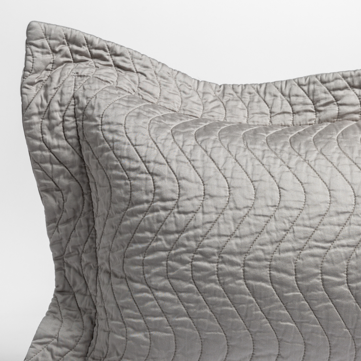 Mineral: a close up of a pillow corner showing the flange framing quilted cotton sateen shot against a white background.