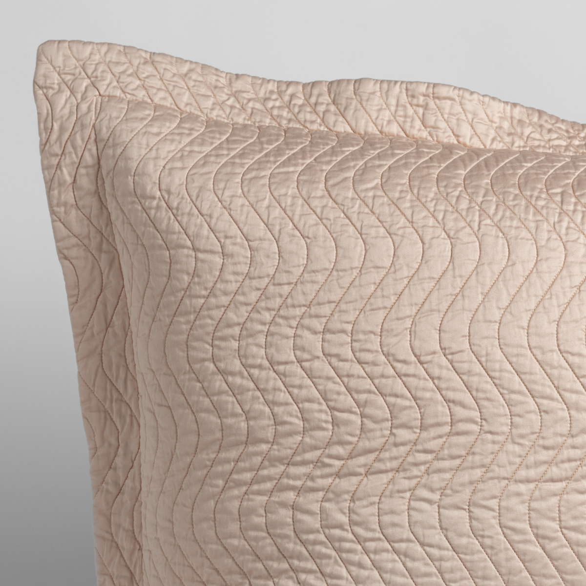 Pearl: a close up of a pillow corner showing the flange framing quilted cotton sateen shot against a white background.