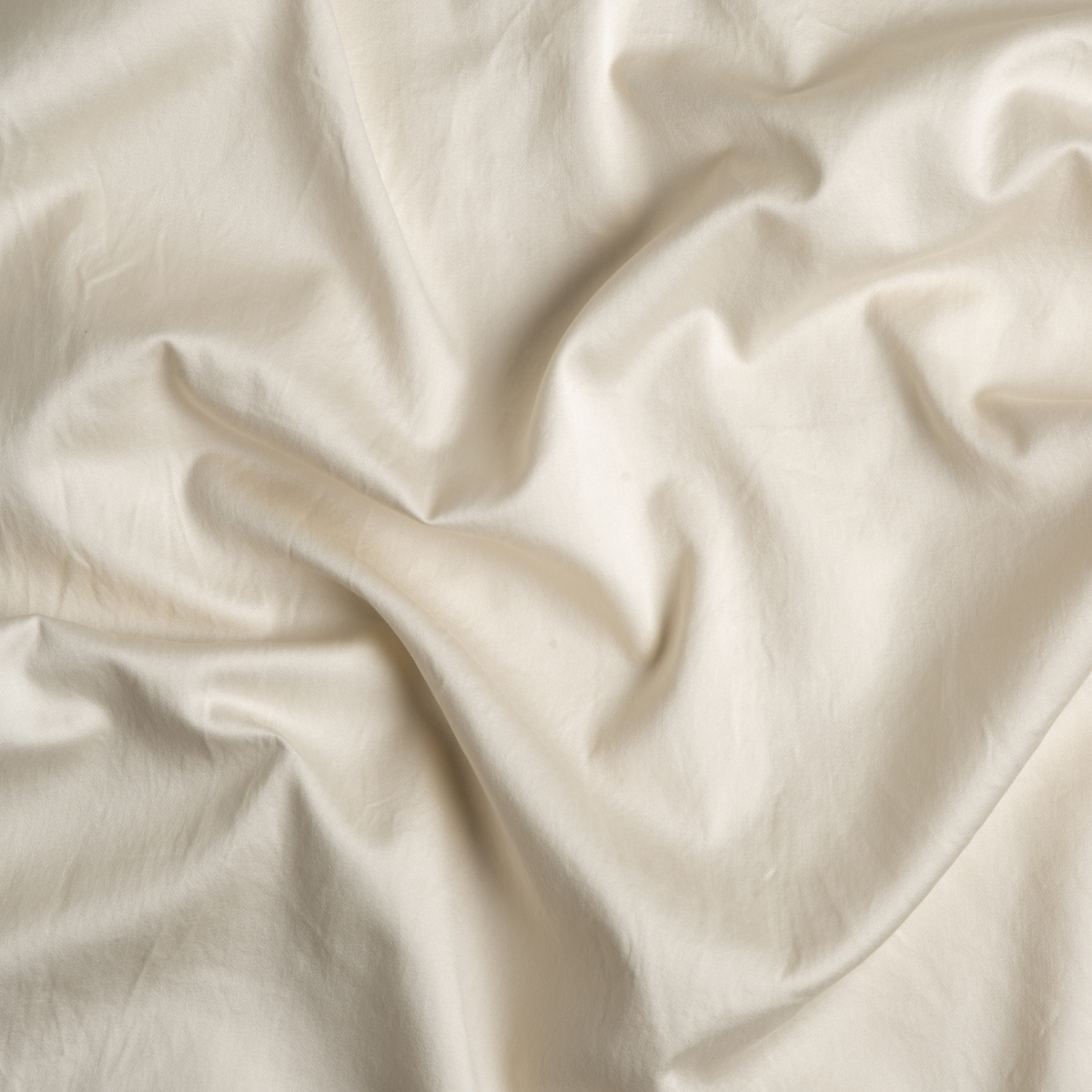Parchment: A close up of cotton sateen fabric in parchment, a warm, antiqued cream.