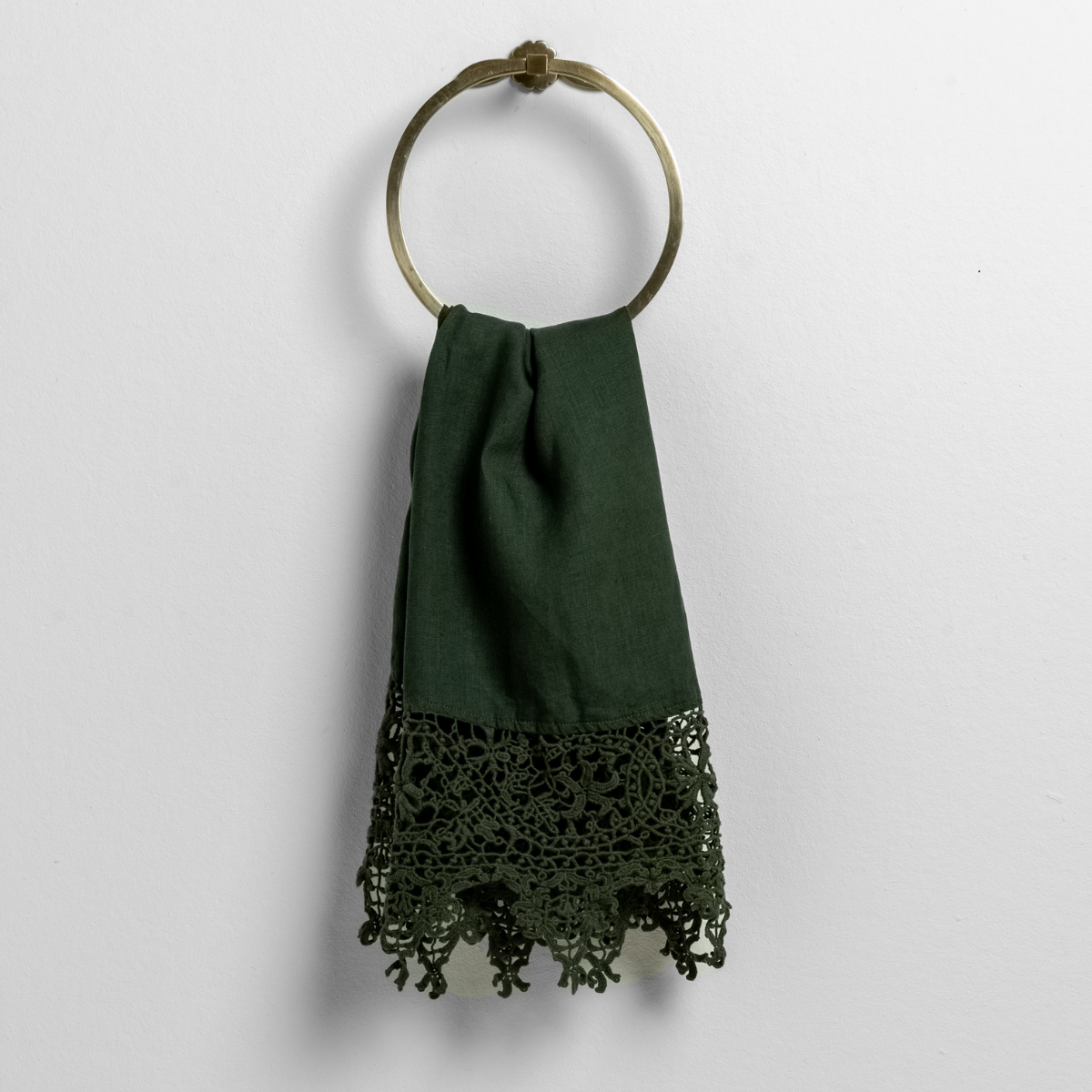 frida lace trimmed linen guest towel folded and hanging from a towel ring against a white background