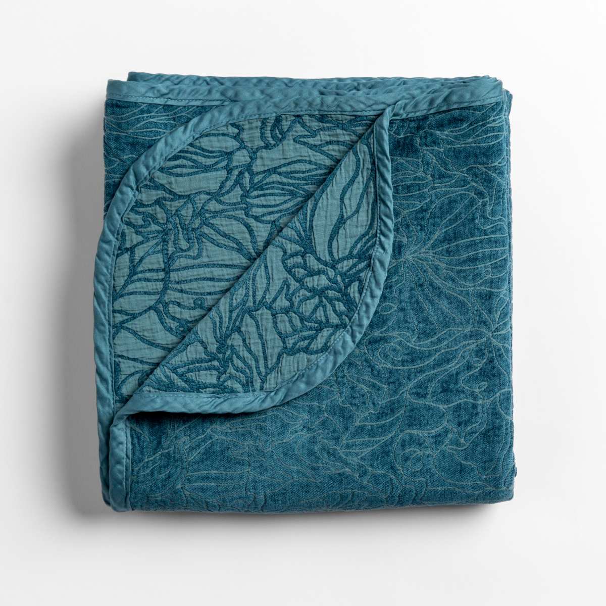 Cenote: folded blanket with its cotton jacquard side visible on the corner foldback against the chenille jacquard side.
