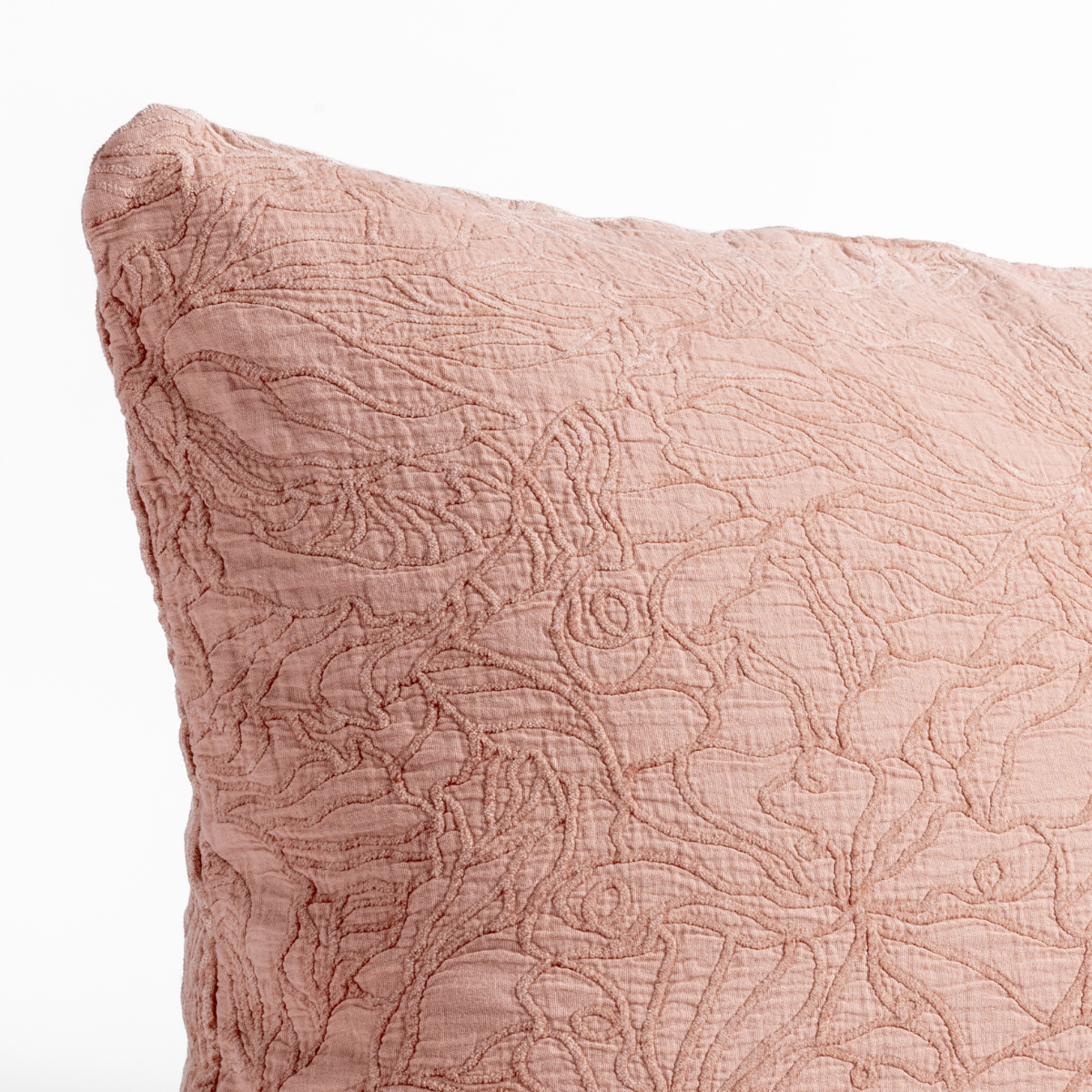 Rouge: close up of the cotton jacquard corner of a pillow cushion with a single-line floral pattern.