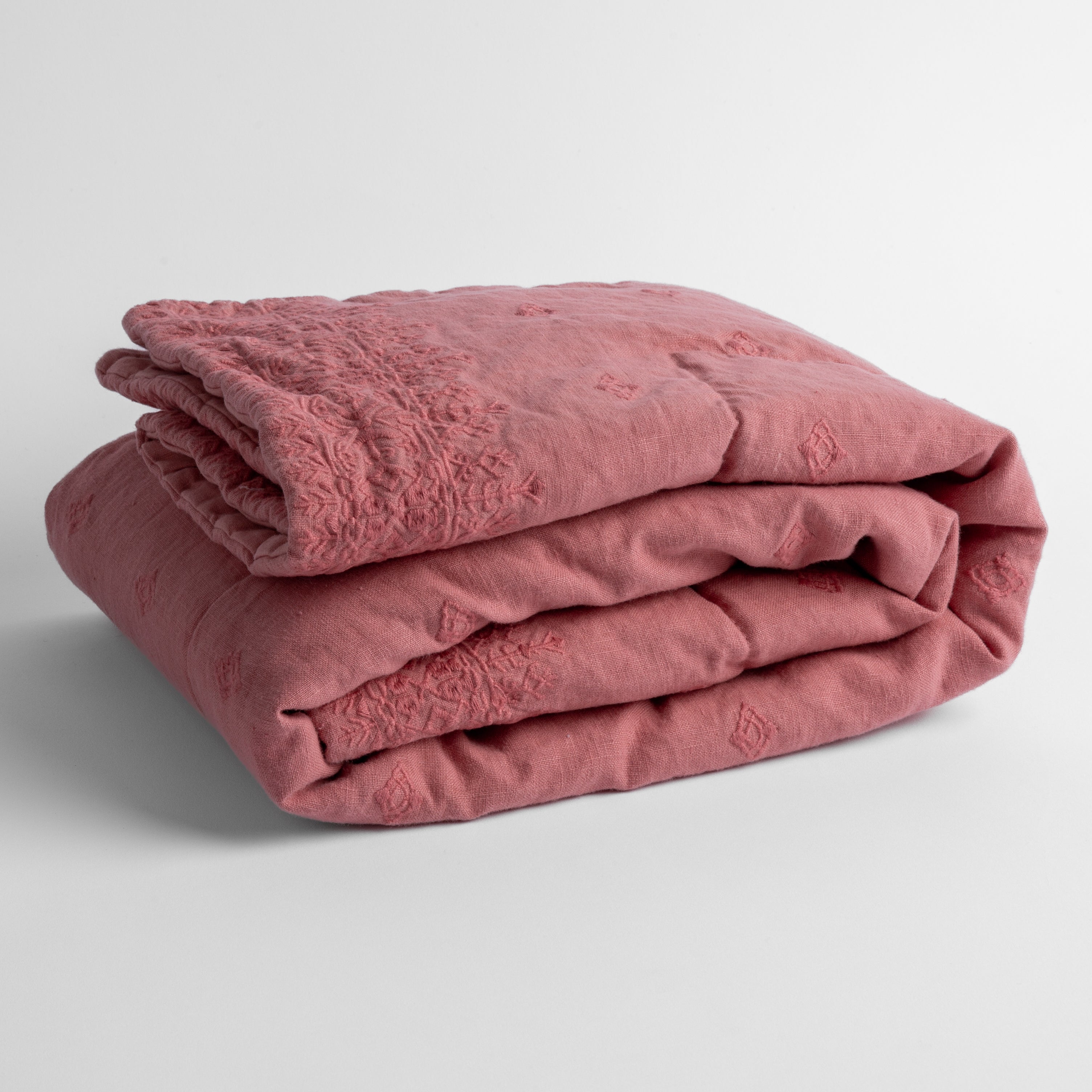 Poppy: embroidered linen baby blanket folded and shown overhead from a slight angle against a white background.