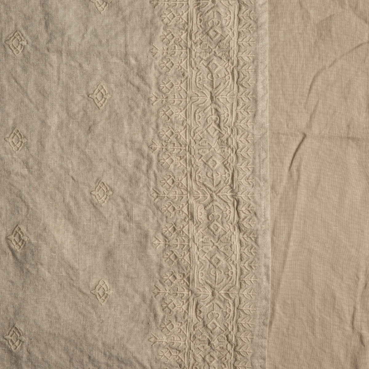 Honeycomb: A close up of embroidered midweight linen fabric in honeycomb, a warm golden tone.