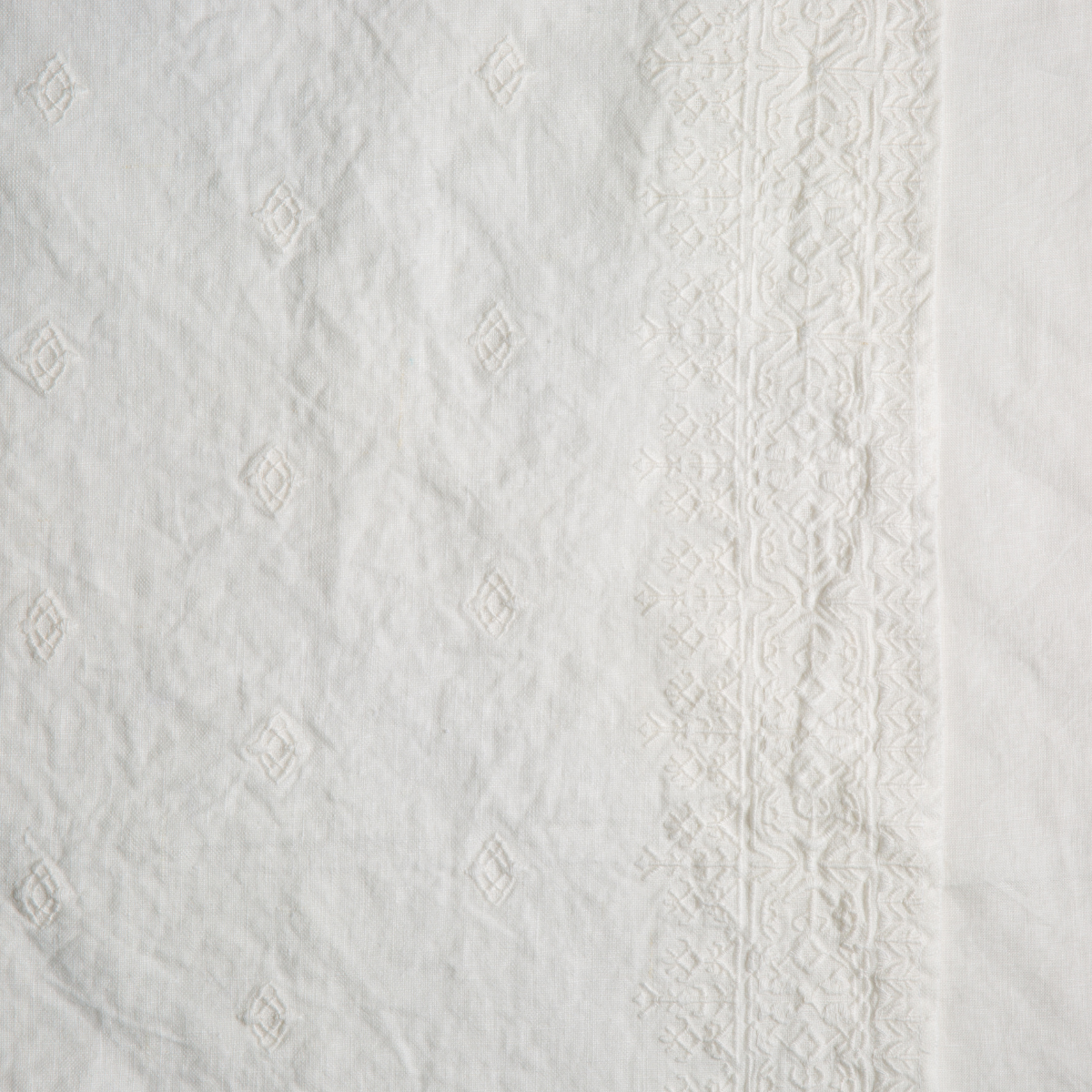 Winter White: A close up of embroidered midweight linen fabric in winter white, softer and warmer in tone than classic white.