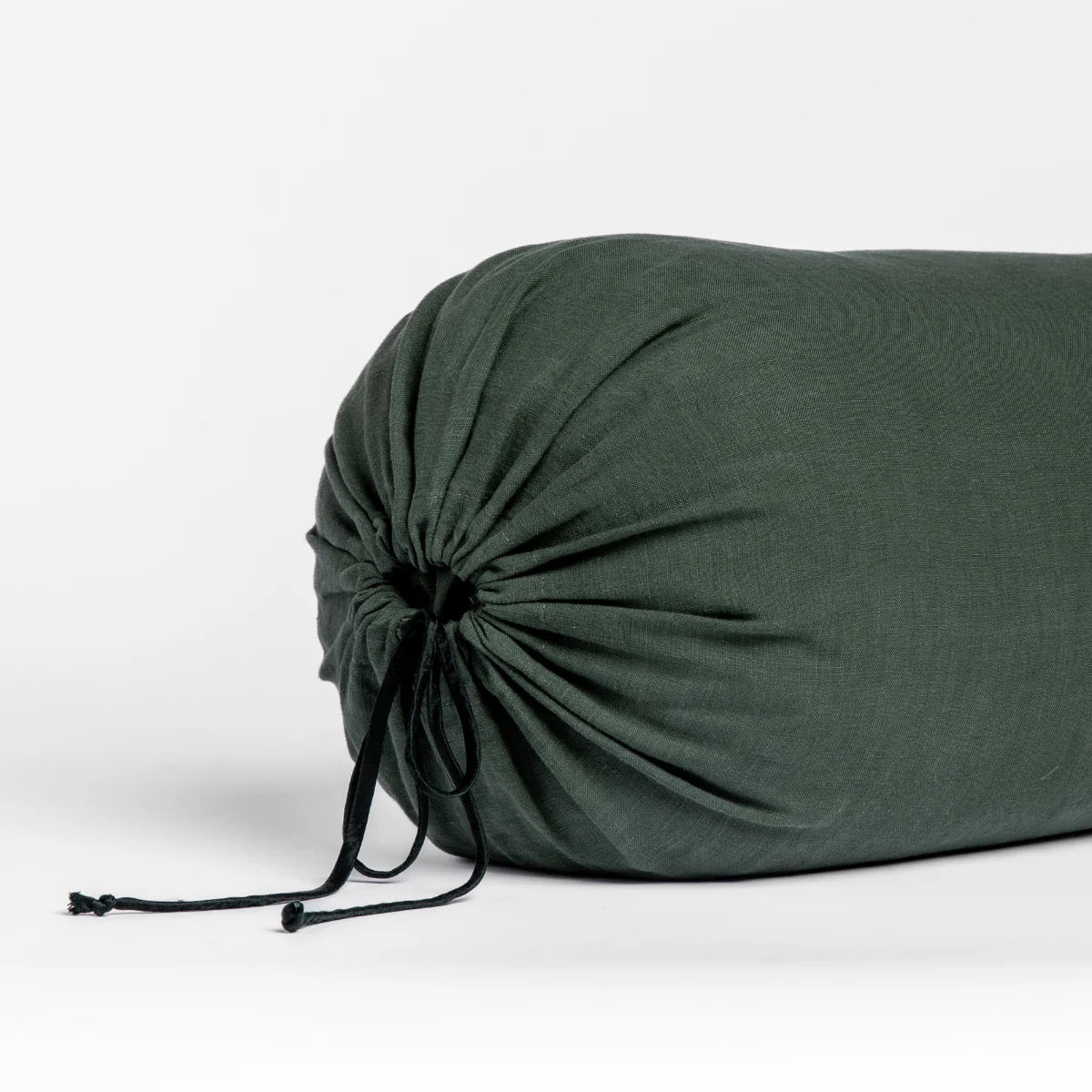 Juniper: Close-up bolster end detail, angled view to show gathered closure and satin ties.