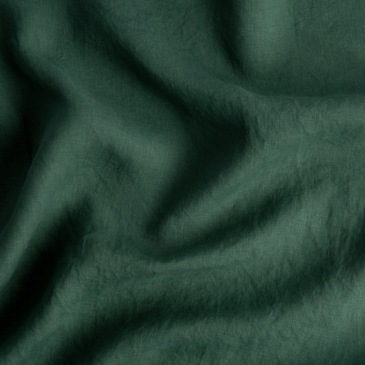 A close up of linen in jade, a rich, verdant green with subtle blue undertones.