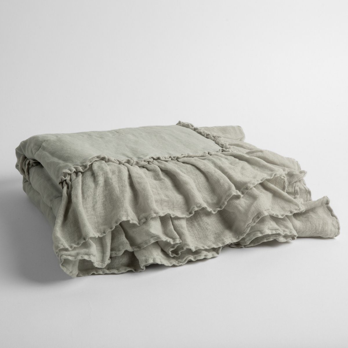 Cloud: a folded linen with linen whisper ruffled blanket folded and positioned to show the ruffle detail against a white background and slightly overhead.