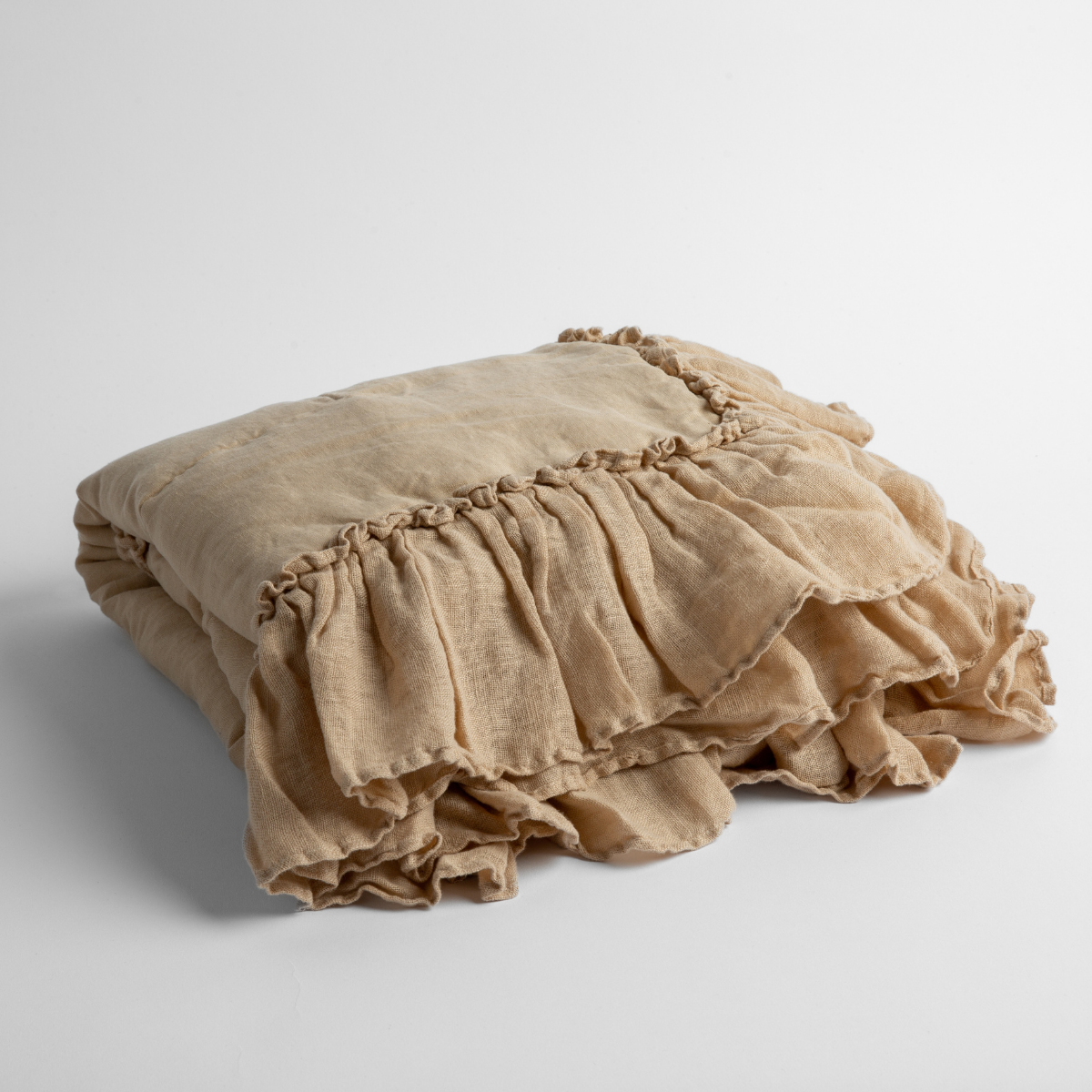 Honeycomb: a folded linen with linen whisper ruffled blanket folded and positioned to show the ruffle detail against a white background and slightly overhead.