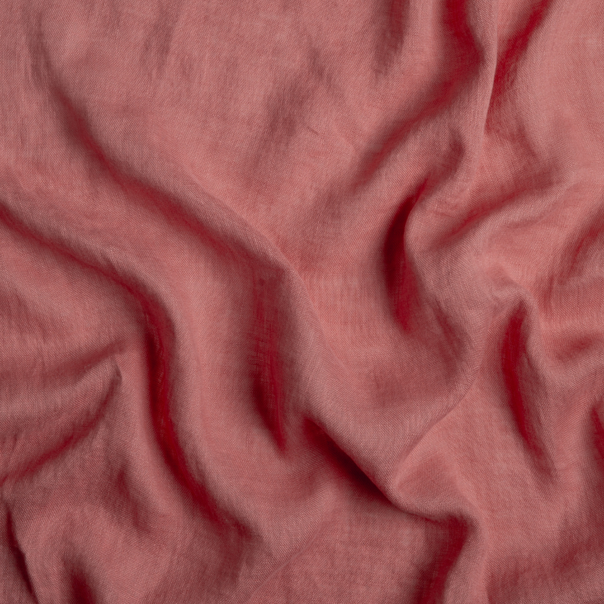 Poppy: A close up of linen whisper fabric in poppy, a warm coral pink.