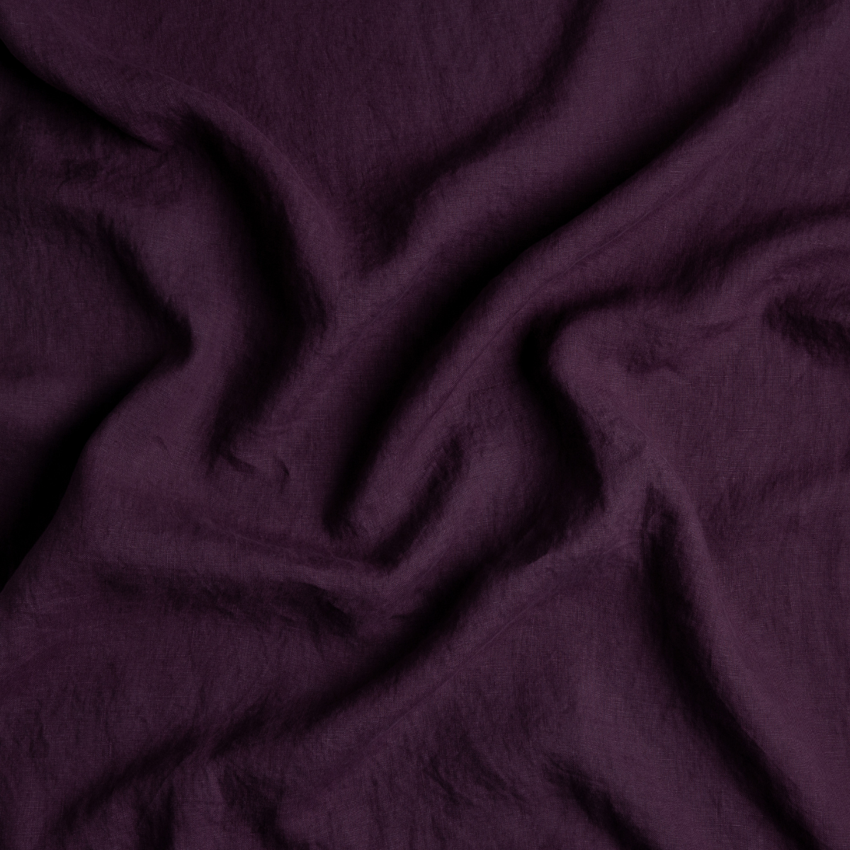 Fig: A close up of linen fabric in fig, a richly saturated purple-garnet.