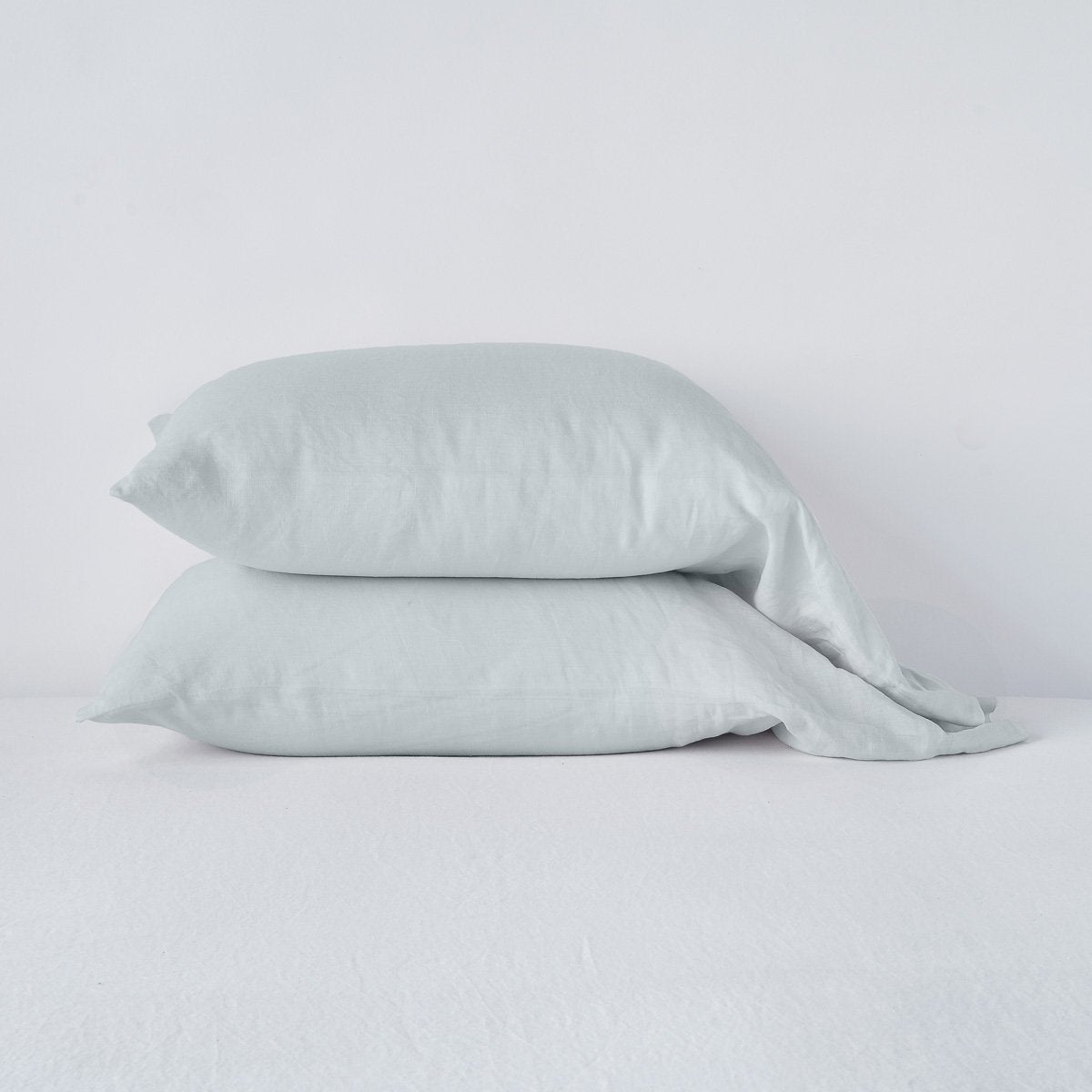 Cloud: Two sleeping pillows neatly stacked against a white background - side view.