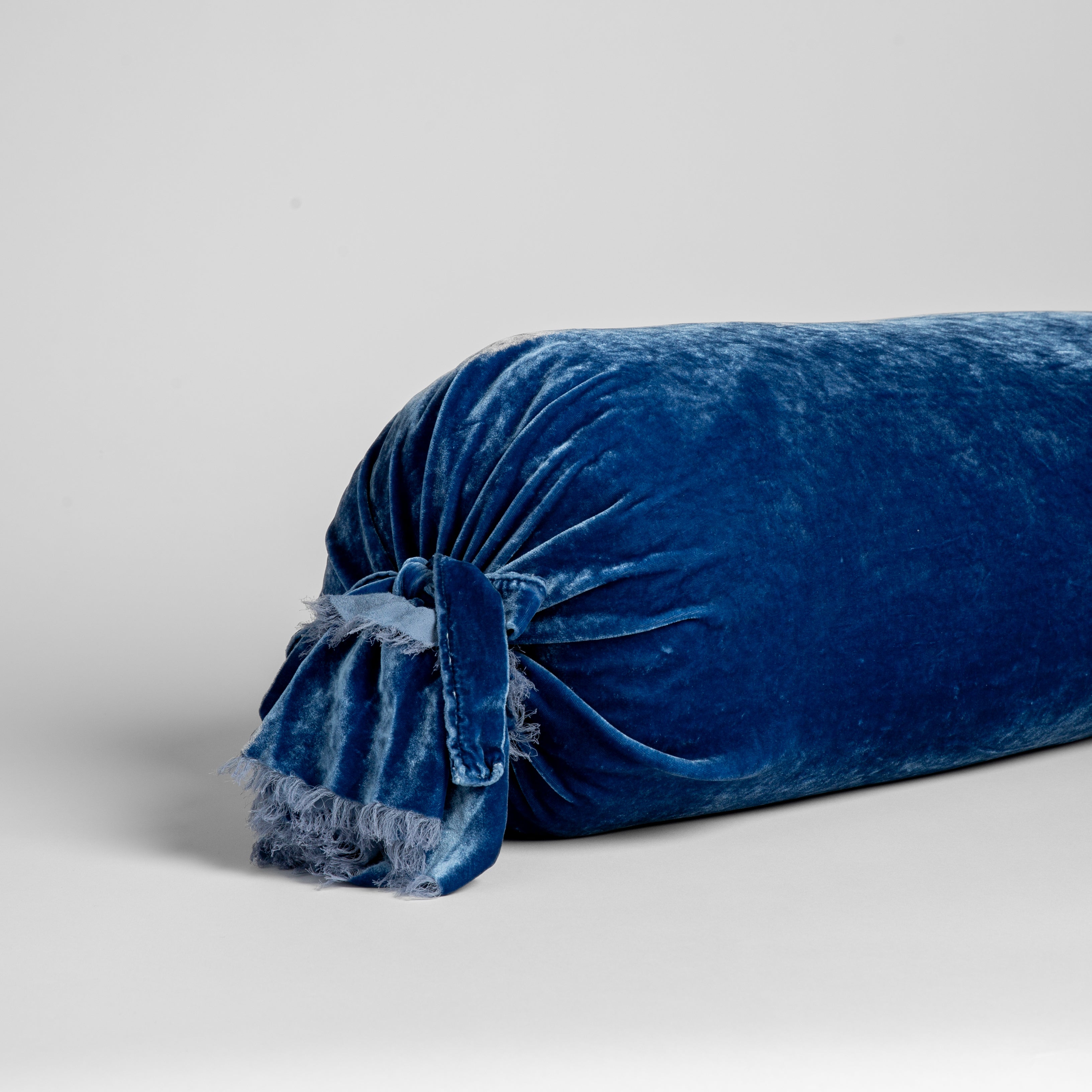 Tahoe Blue: a close up of the end of a bolster pillow showing the raw edge ruffle on the tied end.