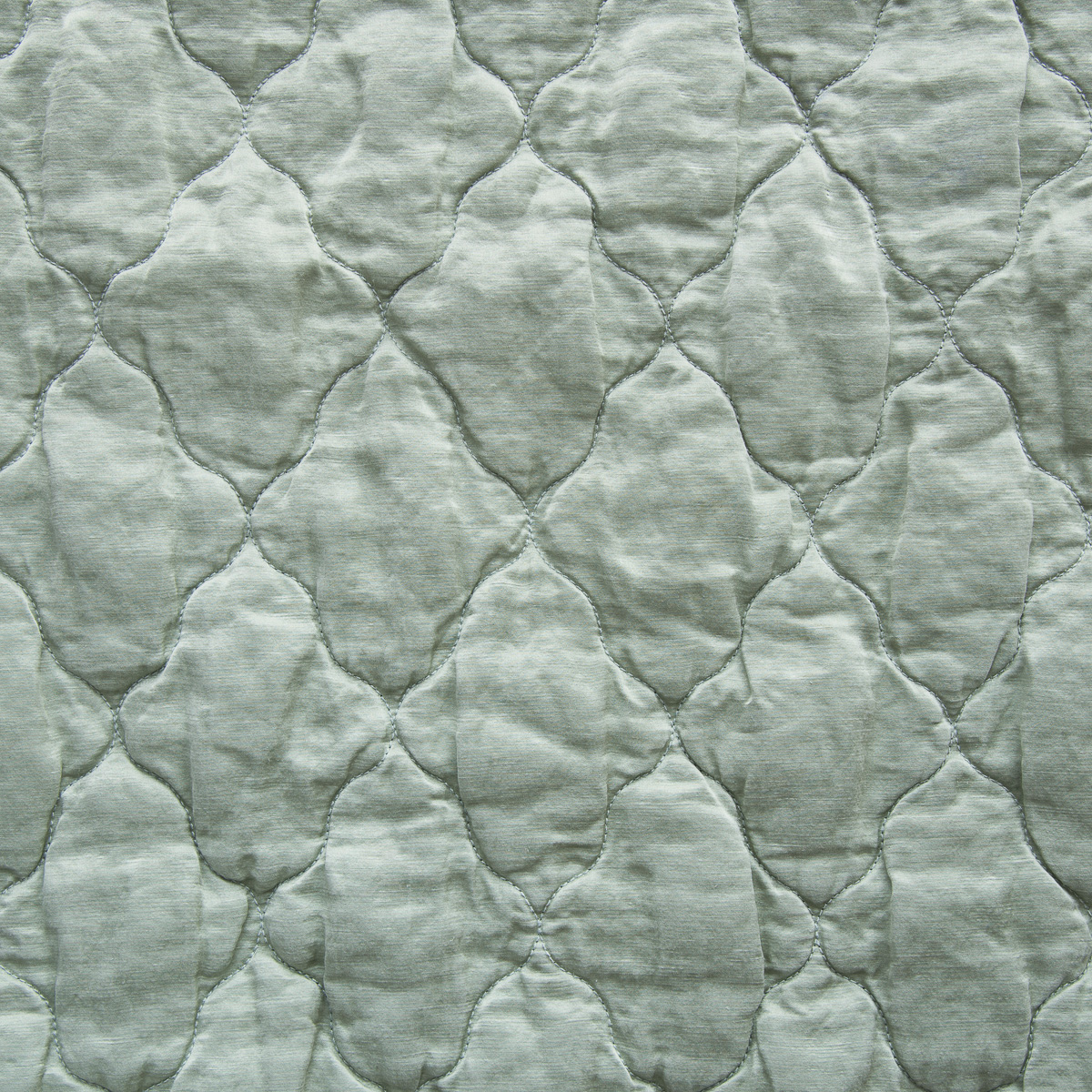 Eucalyptus: A close up of quilted charmeuse fabric in eucalyptus, a soft light green.