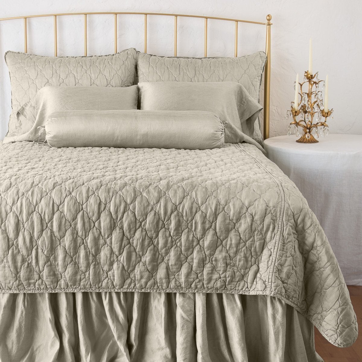 Fog: coverlet on a shining, monochromatic bed with matching shams - end of bed view.