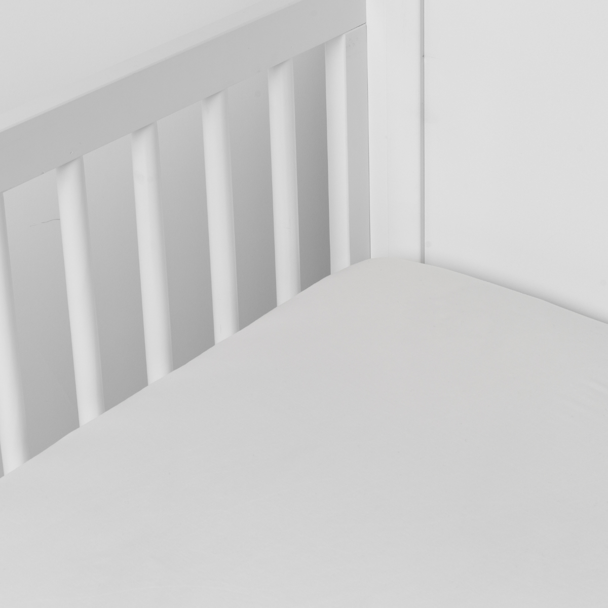 Winter White: crib sheet shown on a mattress shown from overhead into the corner of a crib.