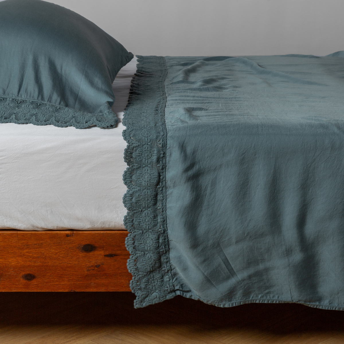 matching cotton lace trimmed flat sheet and pillowcase shown with simple white sheet - side view.