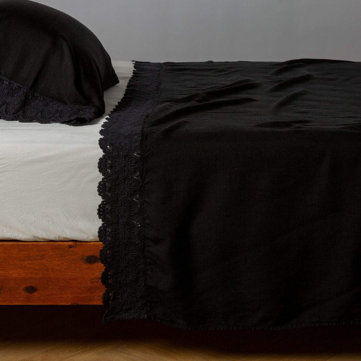 matching cotton lace trimmed flat sheet and pillowcase shown with simple white sheet - side view.