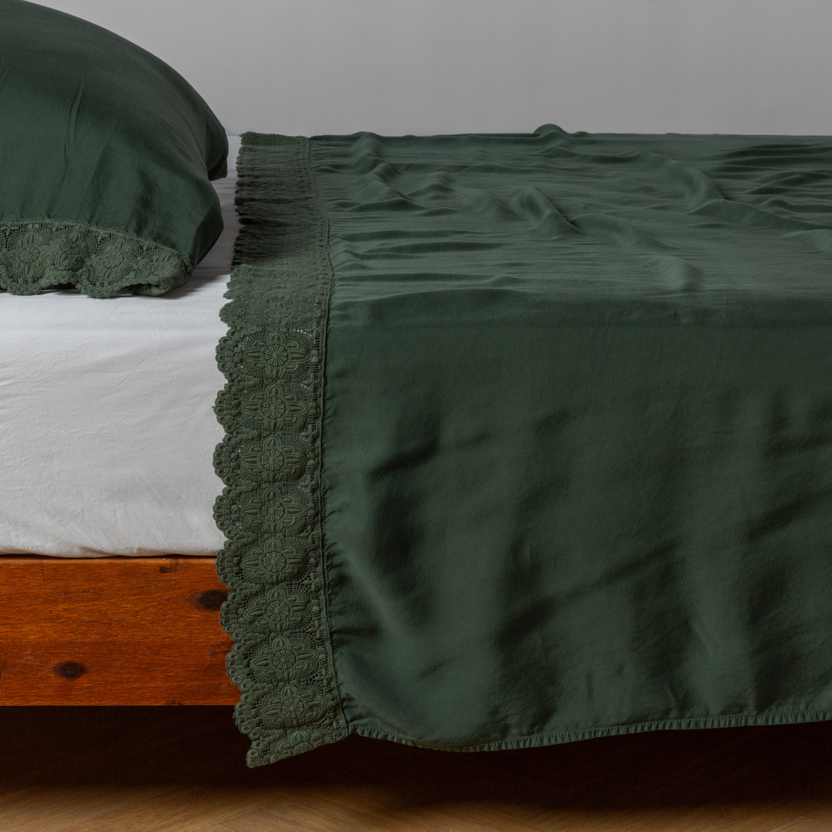 matching cotton lace trimmed flat sheet and pillowcase shown with simple white sheet - side view.