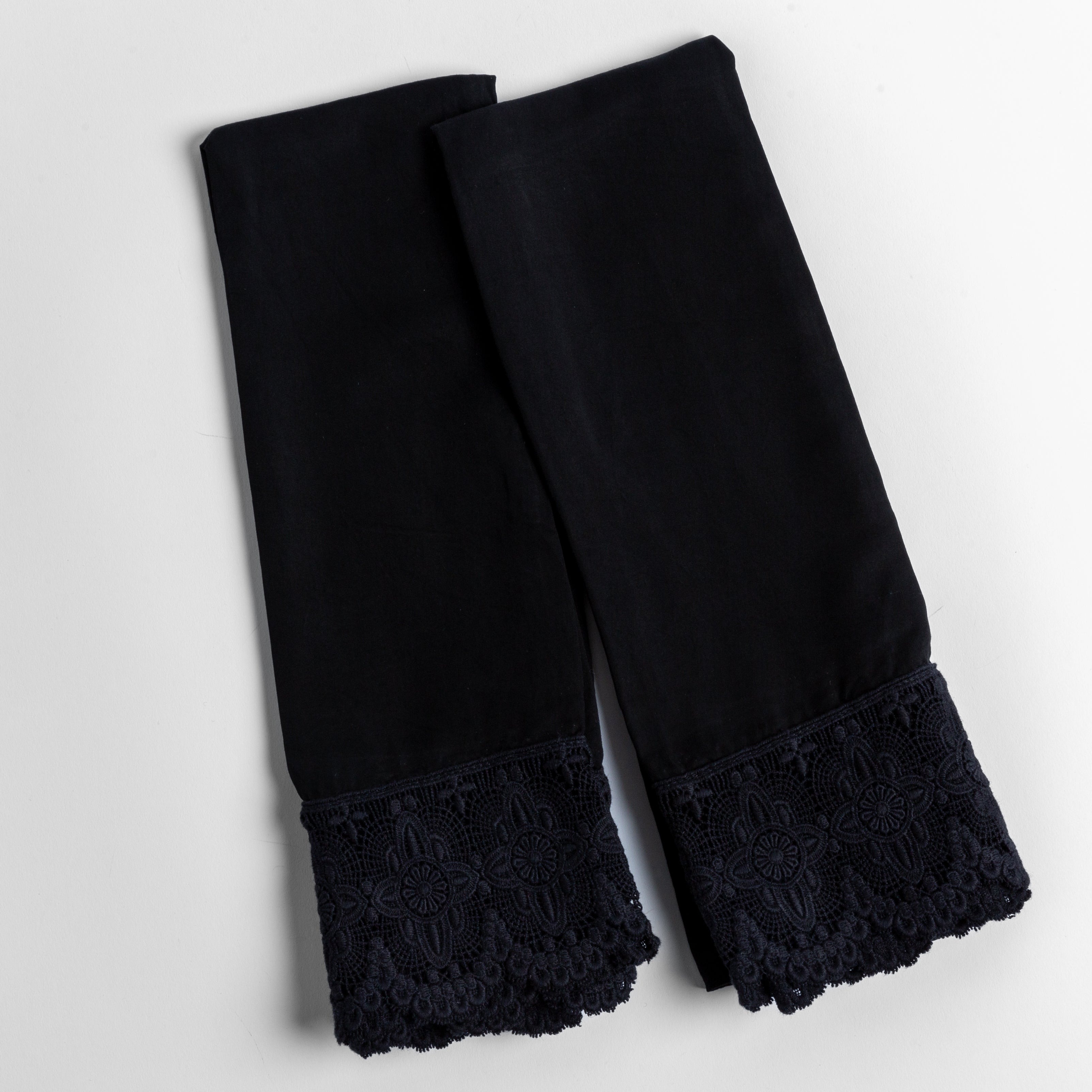 cotton lace trimmed tencel pillowcases folded and shot from overhead against a white background