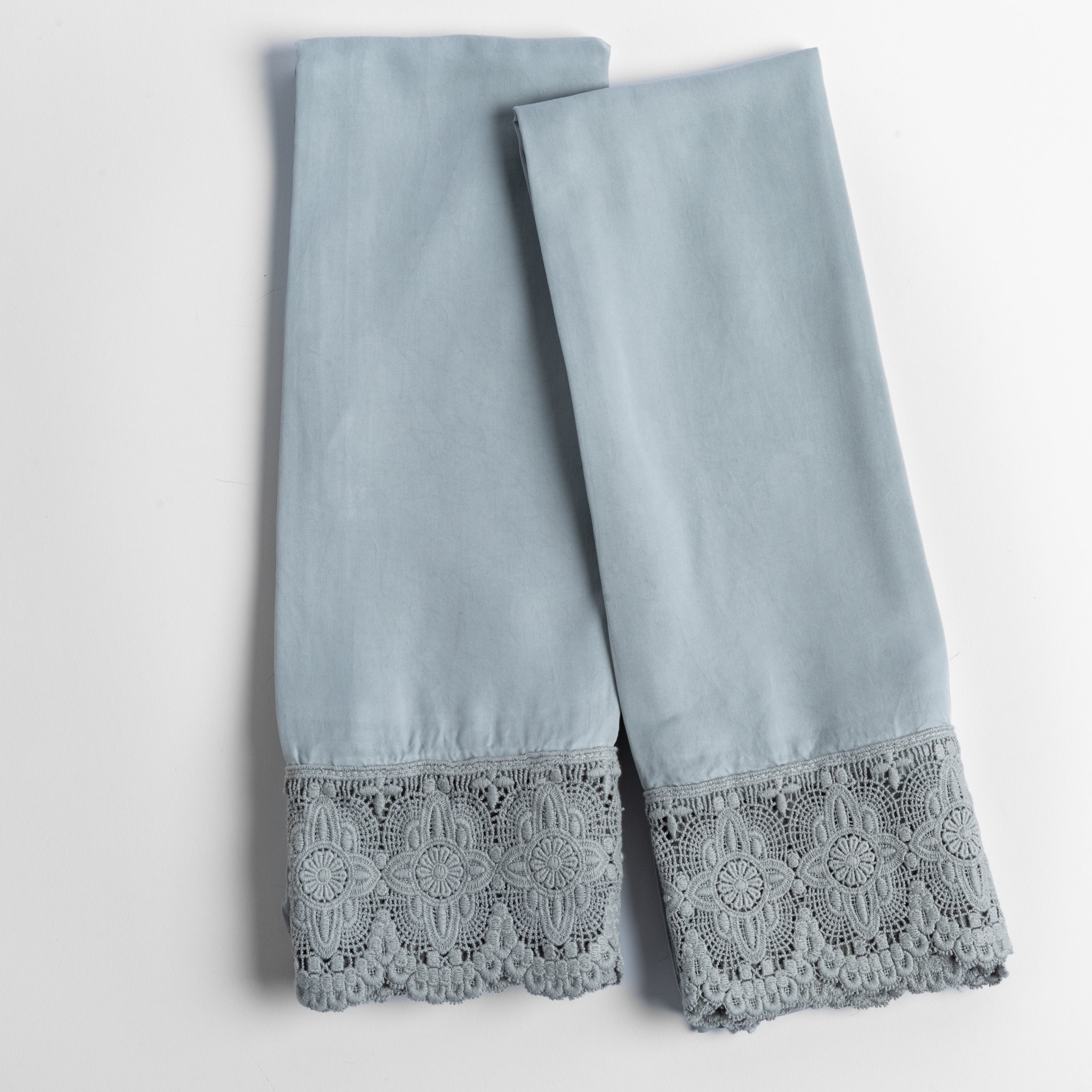 cotton lace trimmed tencel pillowcases folded and shot from overhead against a white background