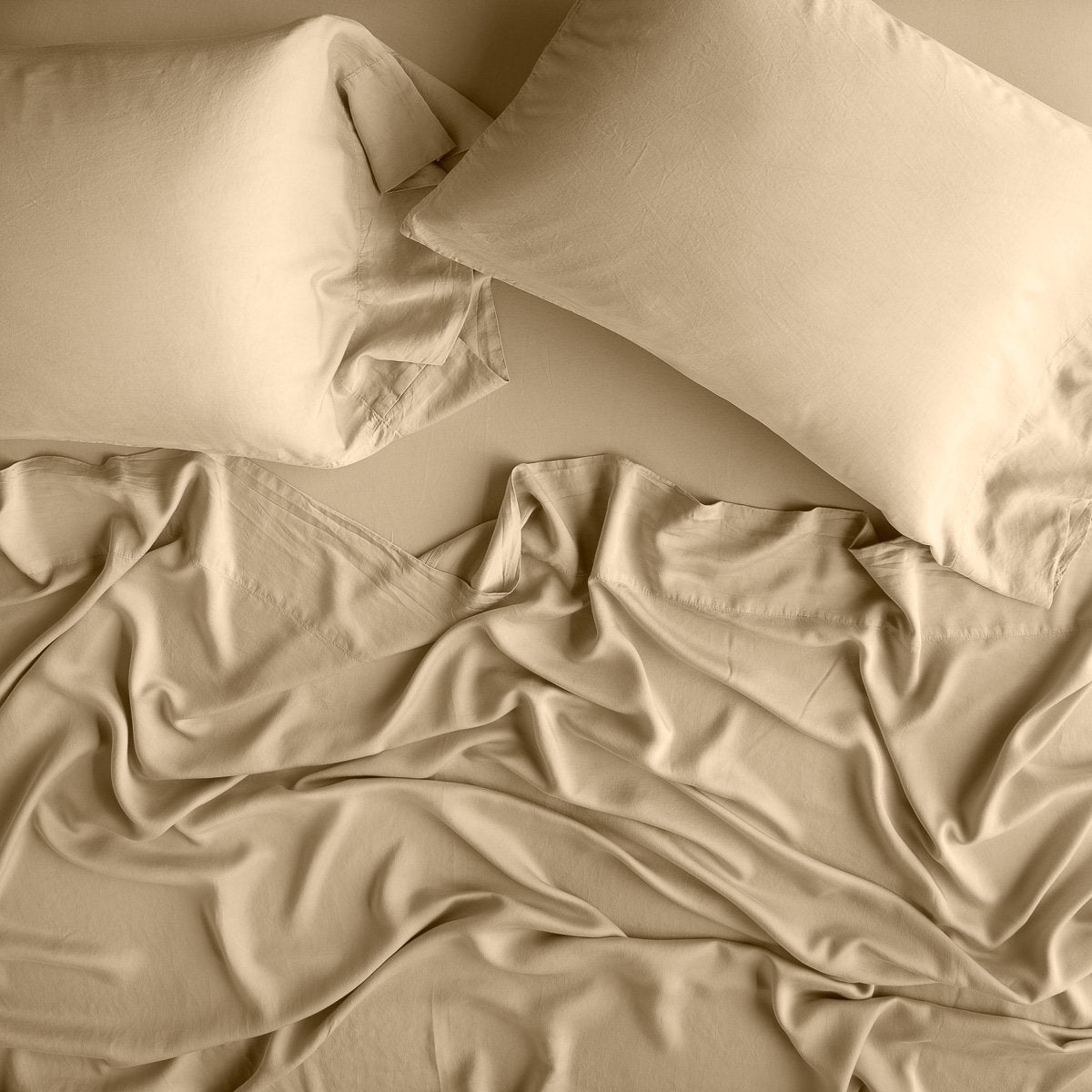 Honeycomb: sleeping pillows laid flat over rumpled matching sheeting - overhead view.