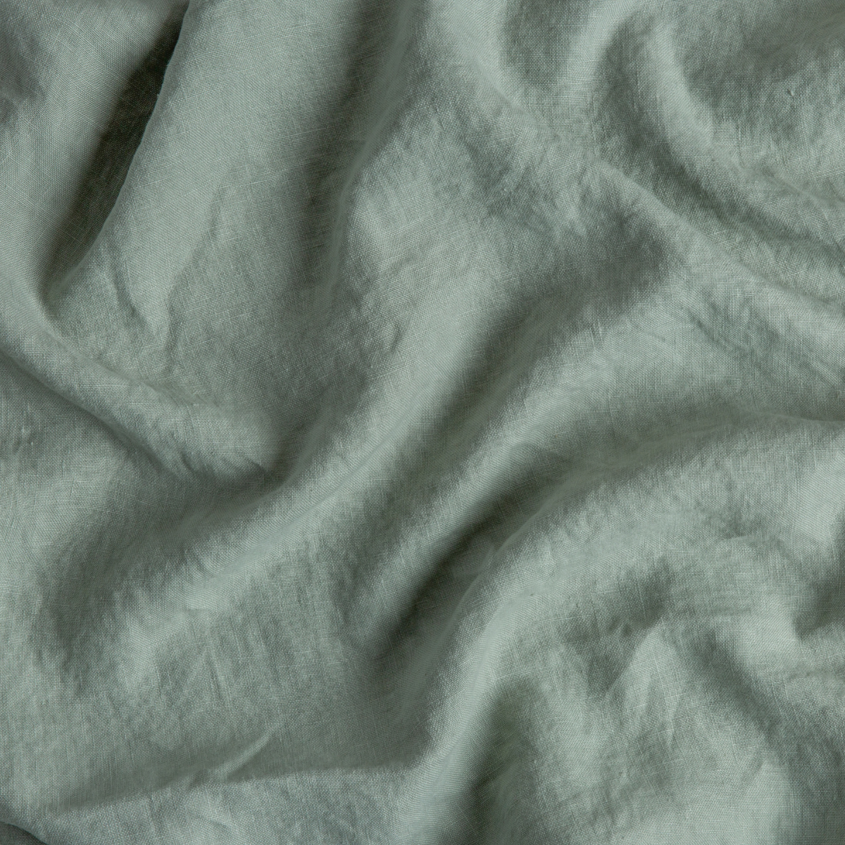 Eucalyptus: A close up of midweight linen fabric in eucalyptus, a soft light green.