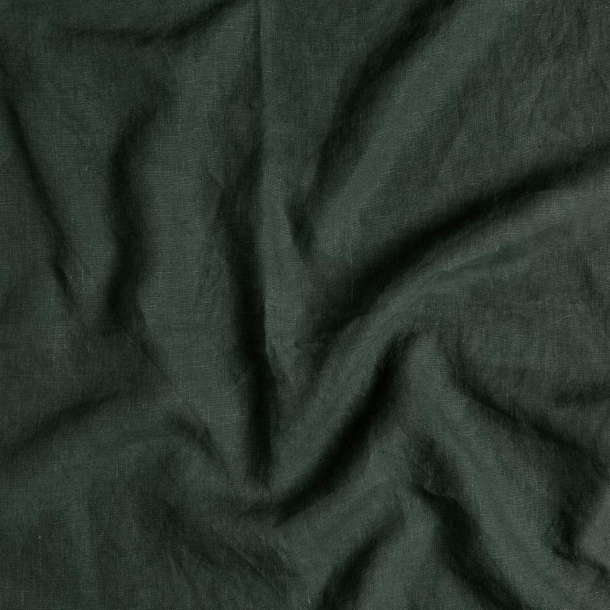 Juniper: A close up of midweight linen fabric in Juniper, a deep green tone.