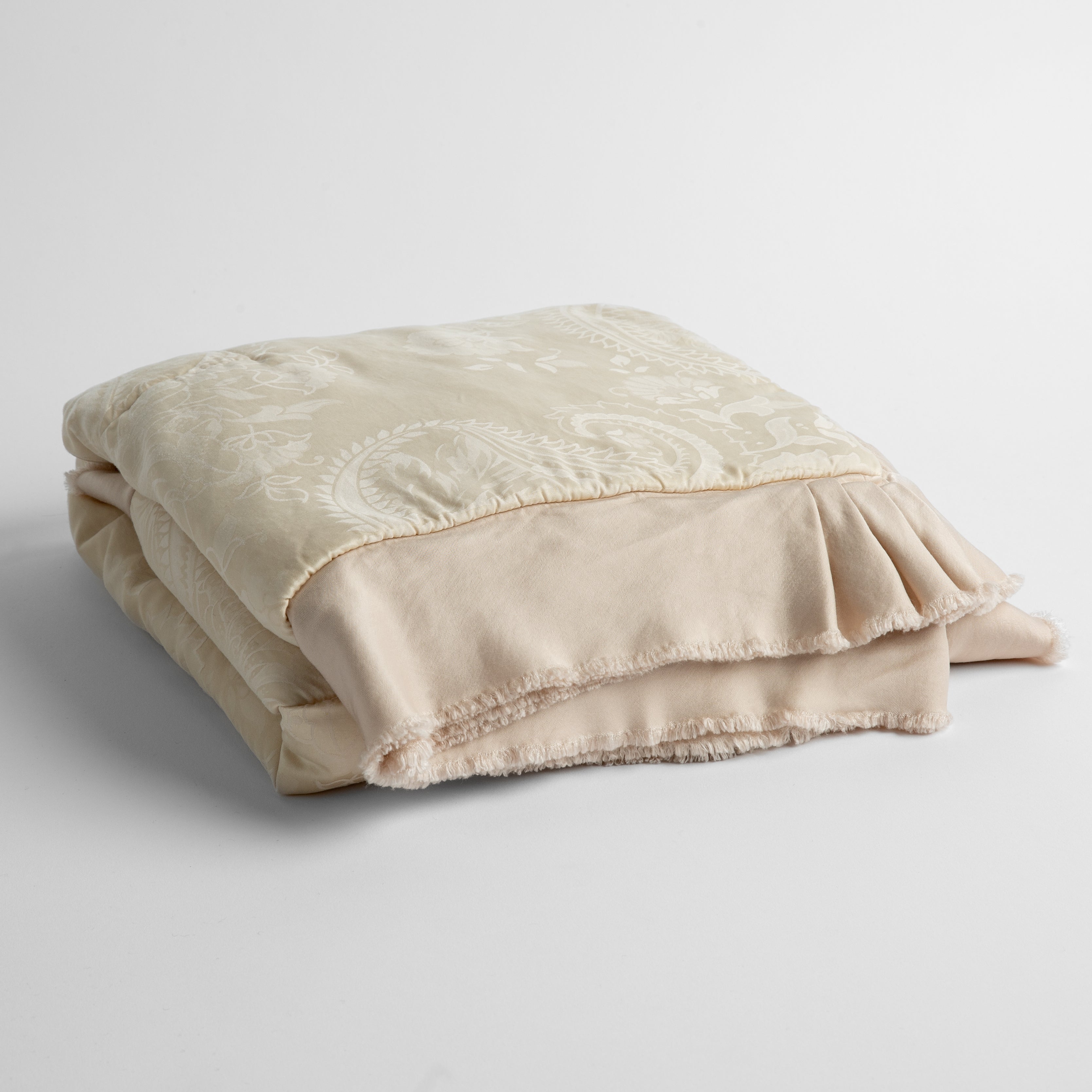 Pearl: silk and tencel™ blend jacquard baby blanket folded and shot from a slight overhead angle to show the trim detail against a white background.