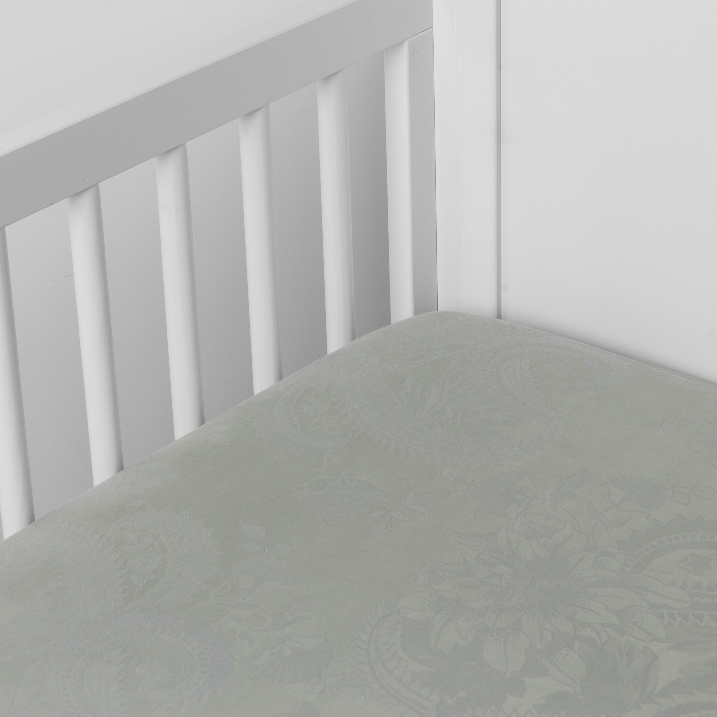 Mineral: a silk and tencel™ crib sheet shown slightly overhread and shot into the corner of a white crib.